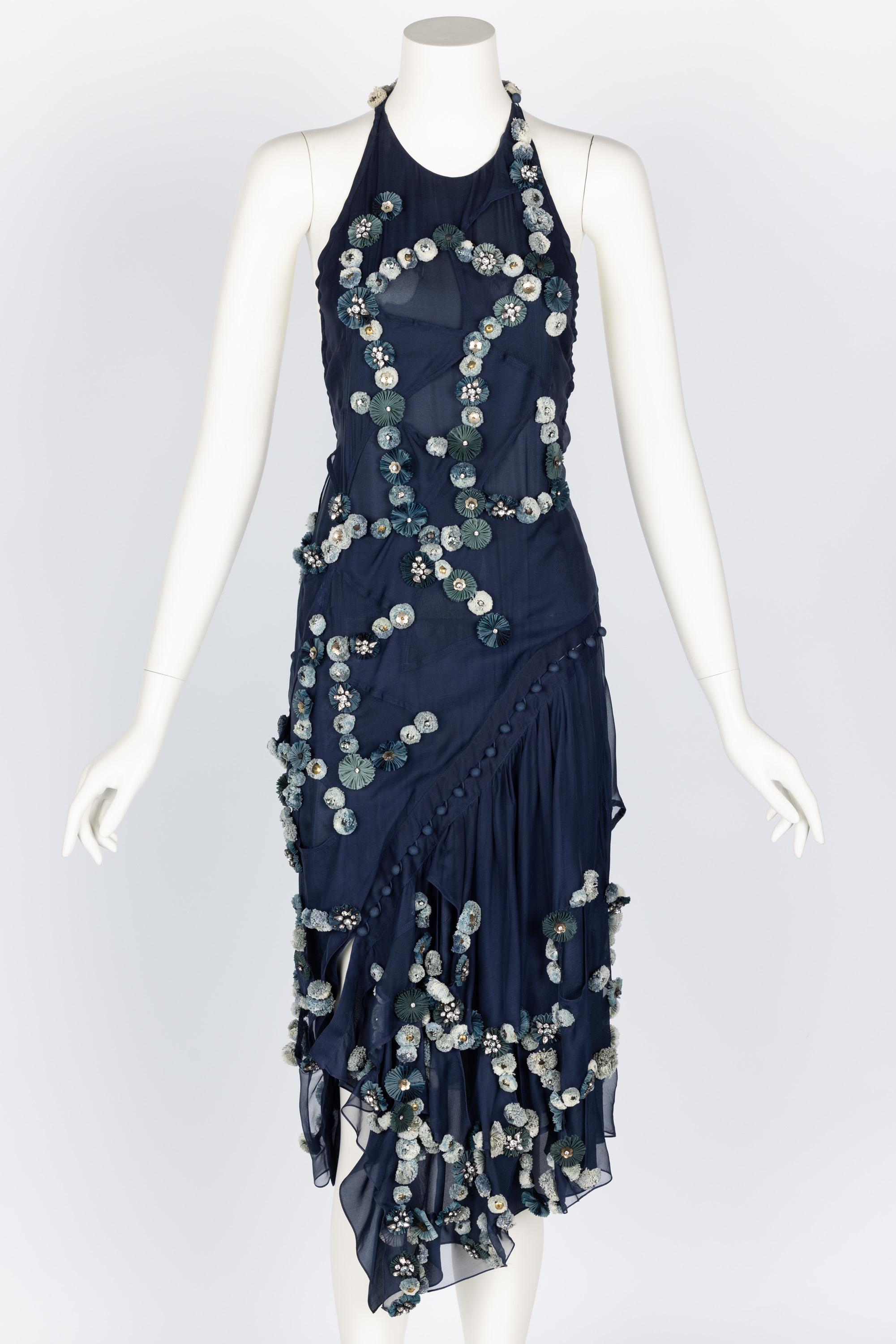 This dress from the Chloé Fall 2008 collection, Look #28, worn by Karlie Kloss, is a striking example of the brand's signature blend of elegance and edge. Crafted from deep navy blue silk, it features a halter neckline and a fitted bodice that