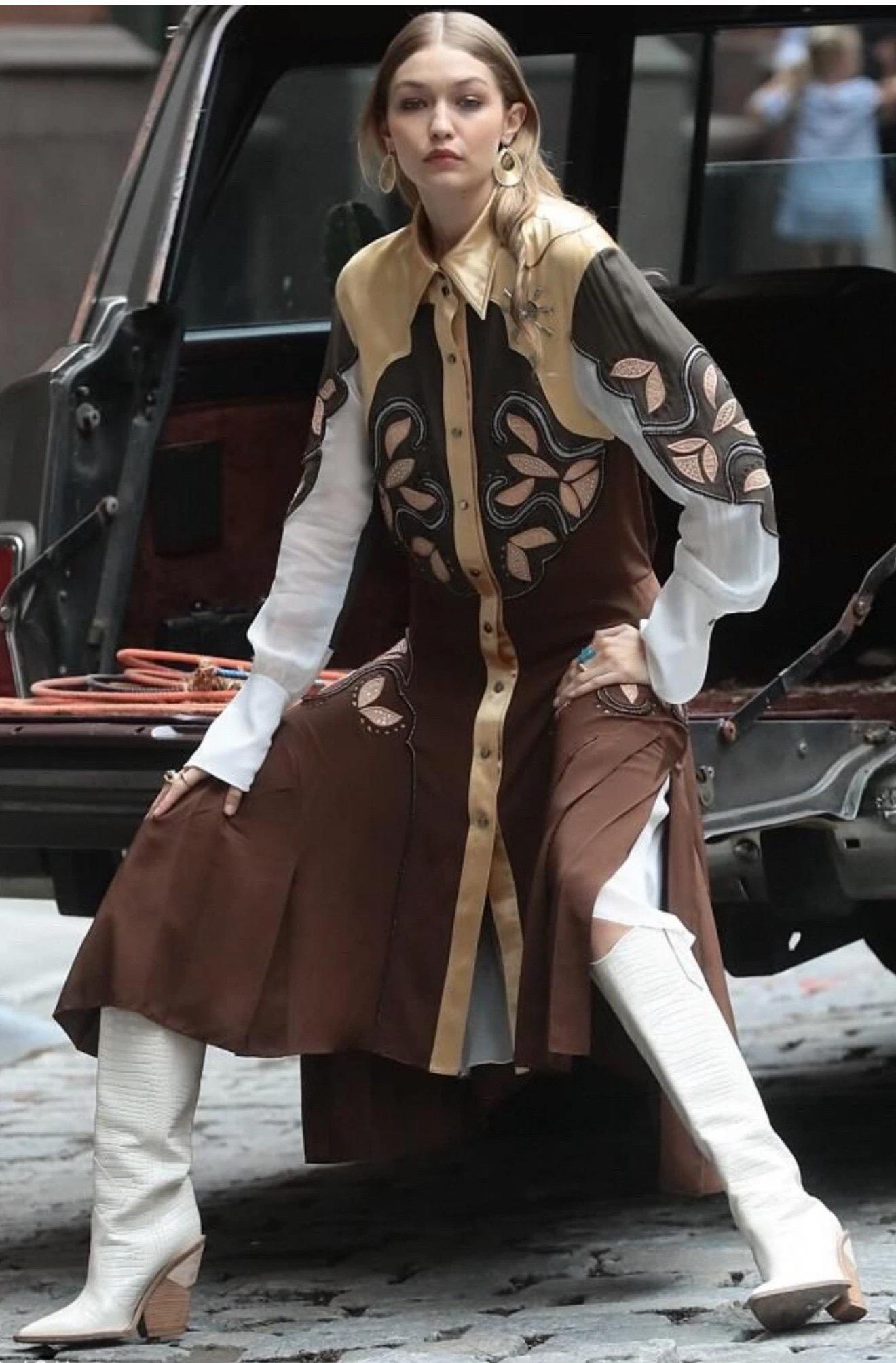 Un pezzo forte della collezione Chloé per l'Autunno/Inverno 2018, questo abito-camicia di ispirazione occidentale mette in mostra l'impegno della maison per l'eccezionale maestria e i dettagli artigianali. Realizzato in seta marrone tonale con