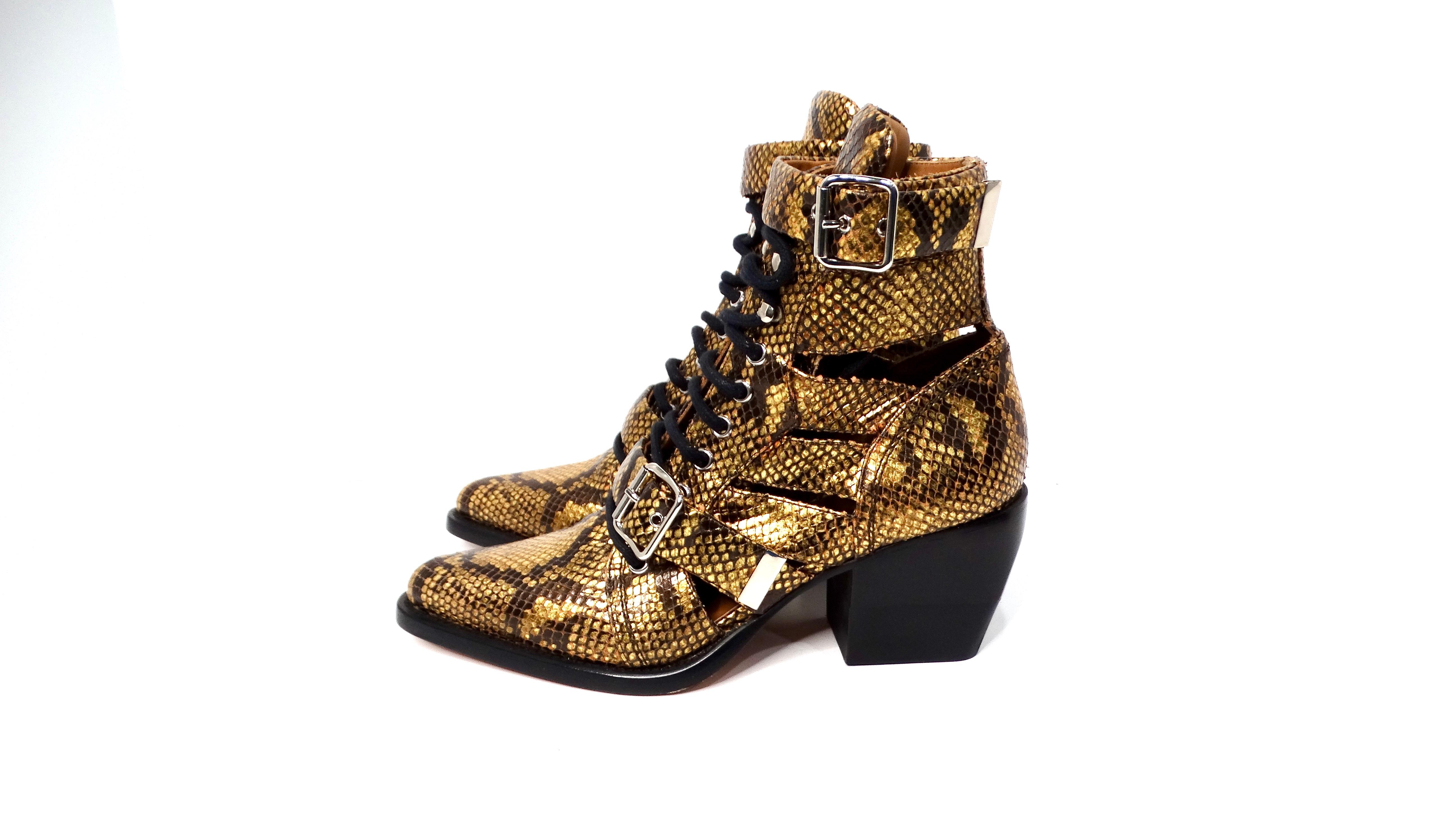 Les bottes à cage en cuir gaufré python Gold de Chloe Rylee sont un mélange étonnant d'audace et d'élégance. Elles sont réalisées en cuir luxueux gaufré python dans une teinte jaune bronze saisissante. Ces bottes présentent un design unique en forme
