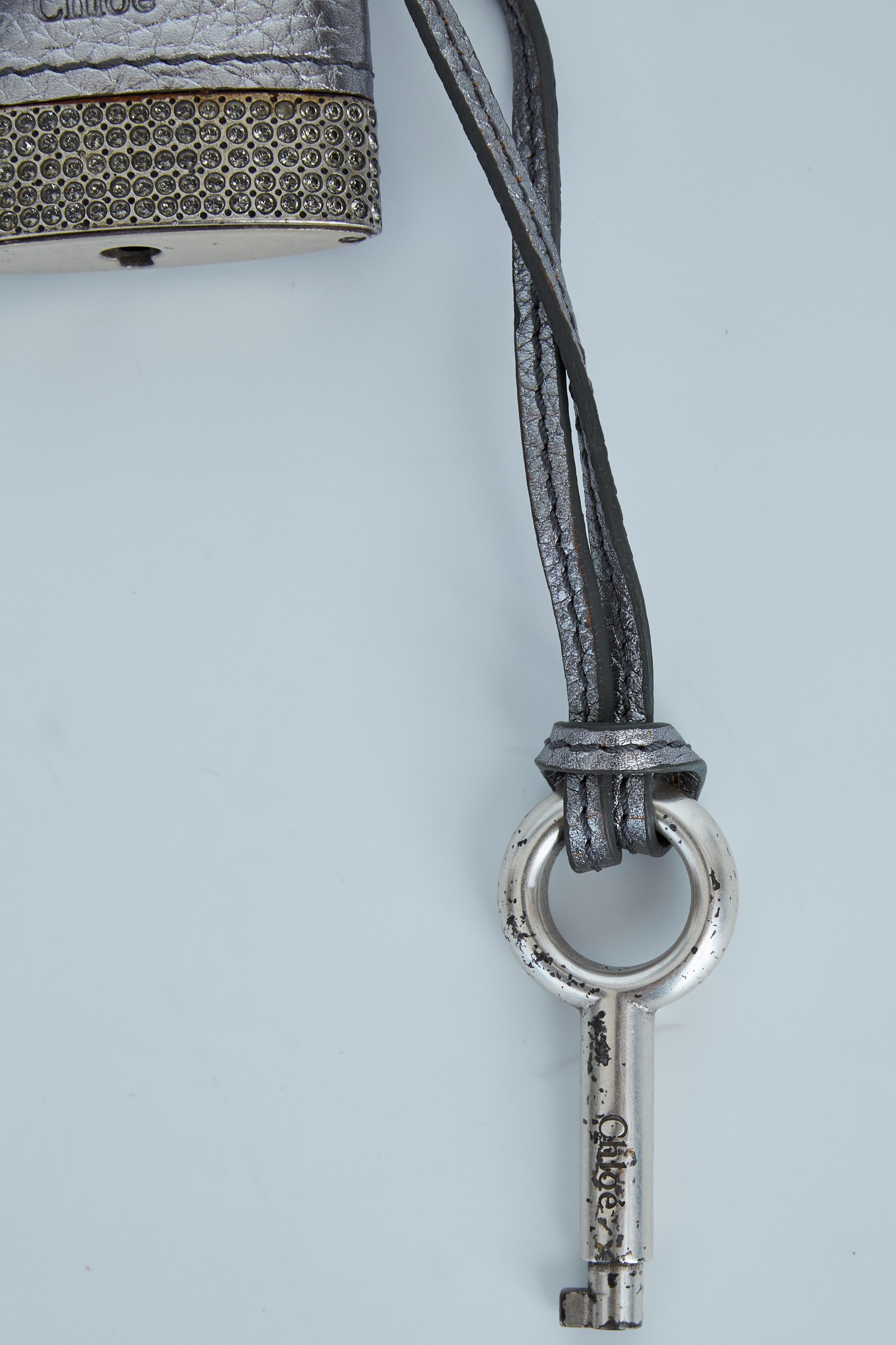 Color: Silver tone
Material: Metal and leather
Measurements: Length 2” x Width 3.5” (Padlock)
Comes with: Box
Condition: Good: faint hairline scratches throughout, scuff marks, tarnish, rust.