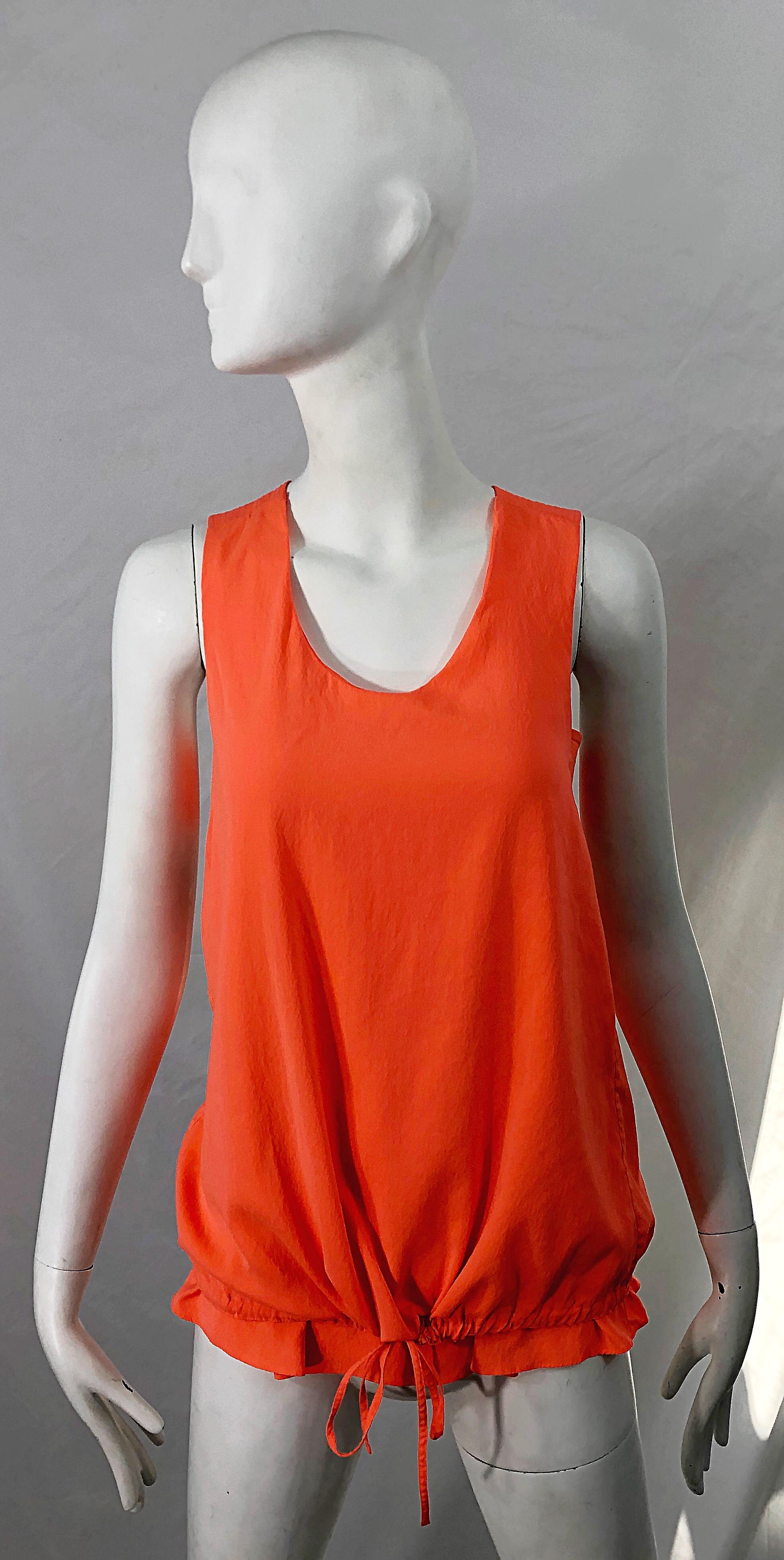 Magnifique chemise sans manches en soie CHLOE by CLARE WAIGHT KELLER ' Orange Fizz ' ! Une couleur orange vibrante sur un luxueux tissu en soie (92%) et élasthanne (8%). Style dos nageur avec des bandes à chaque ouverture de manche. Le cordon de