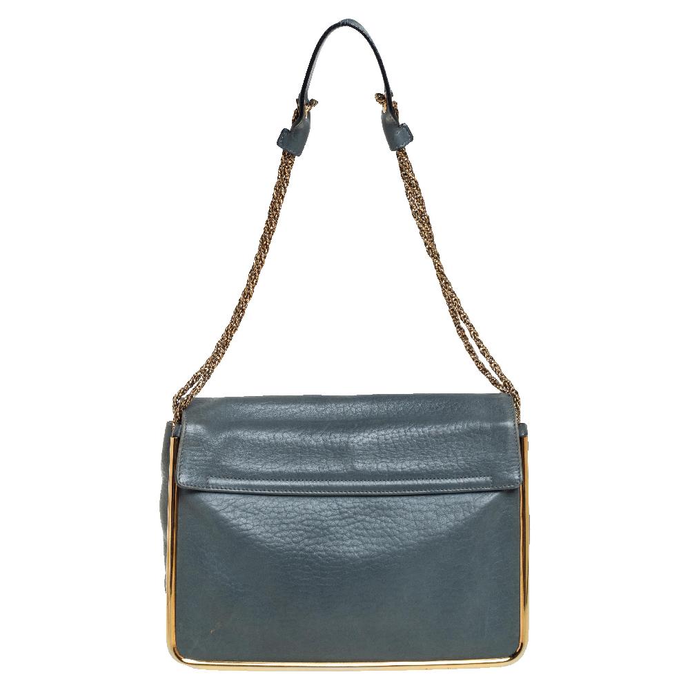 This stylish Sally shoulder bag from Chole is crafted from stone blue-hued leather. The bag features a chain-link strap with a leather shoulder rest and a stunning flip-lock in gold tone. The flap opens to a spacious canvas-lined interior that