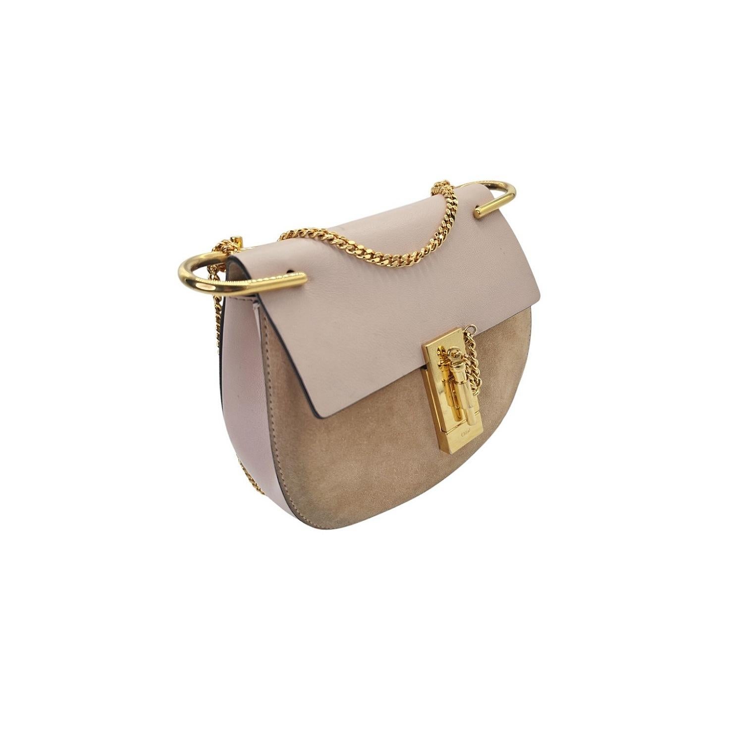 Indulge in luxury with the Chloe Suede Calfskin Suede Mini Drew Shoulder Bag. Made from smooth calfskin leather, this elegant bag features a chain link crossbody strap and a unique peg-and-eye turn-lock closure. The interior is lined with soft suede
