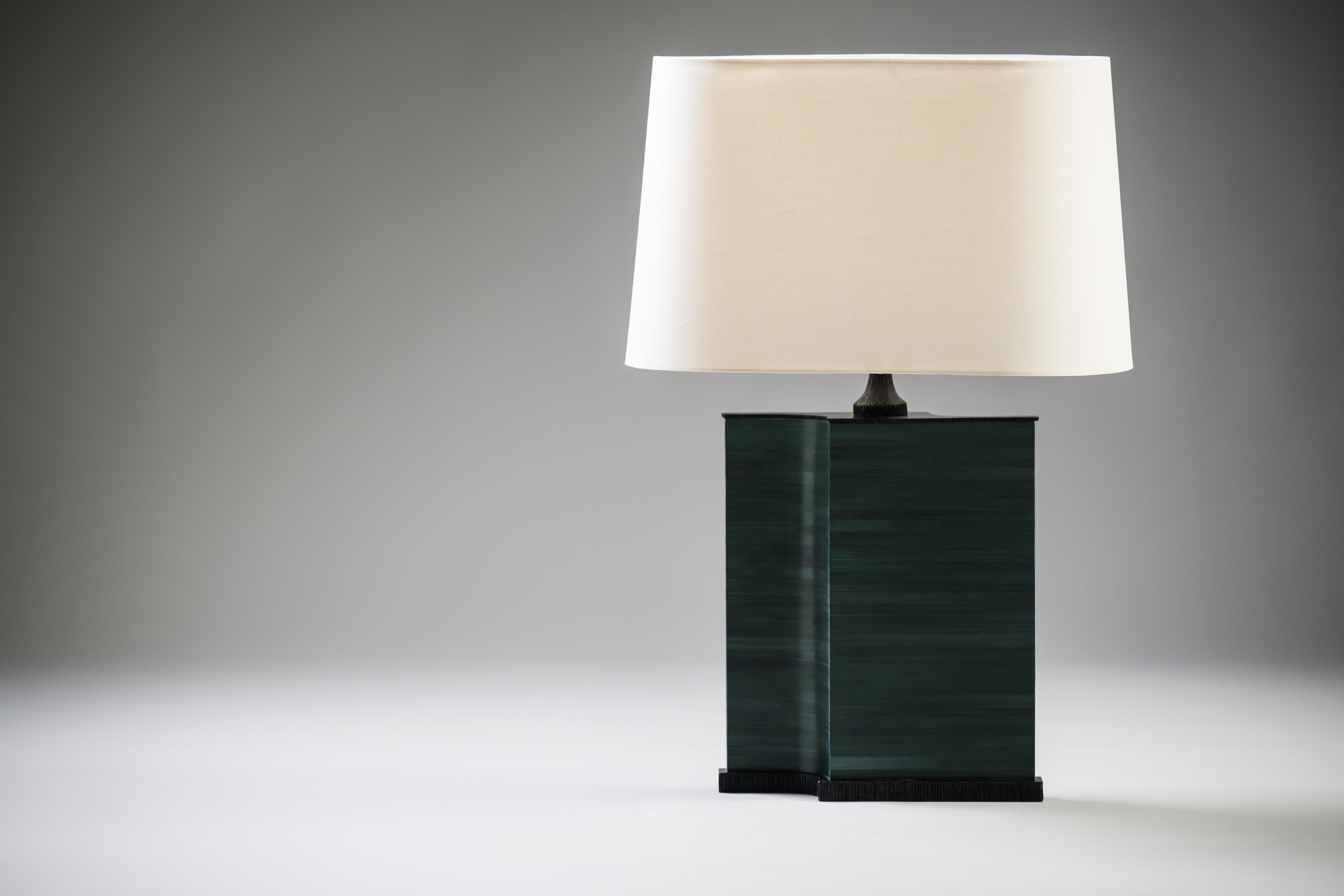 Lampada da tavolo su ordinazione di Elan Atelier. Il tempo di produzione è di dieci settimane più la spedizione internazionale.

Base con intarsio di paglia verde e bronzo scuro. Paralume ovale in tessuto bianco sporco.

Dimensioni complessive:
L