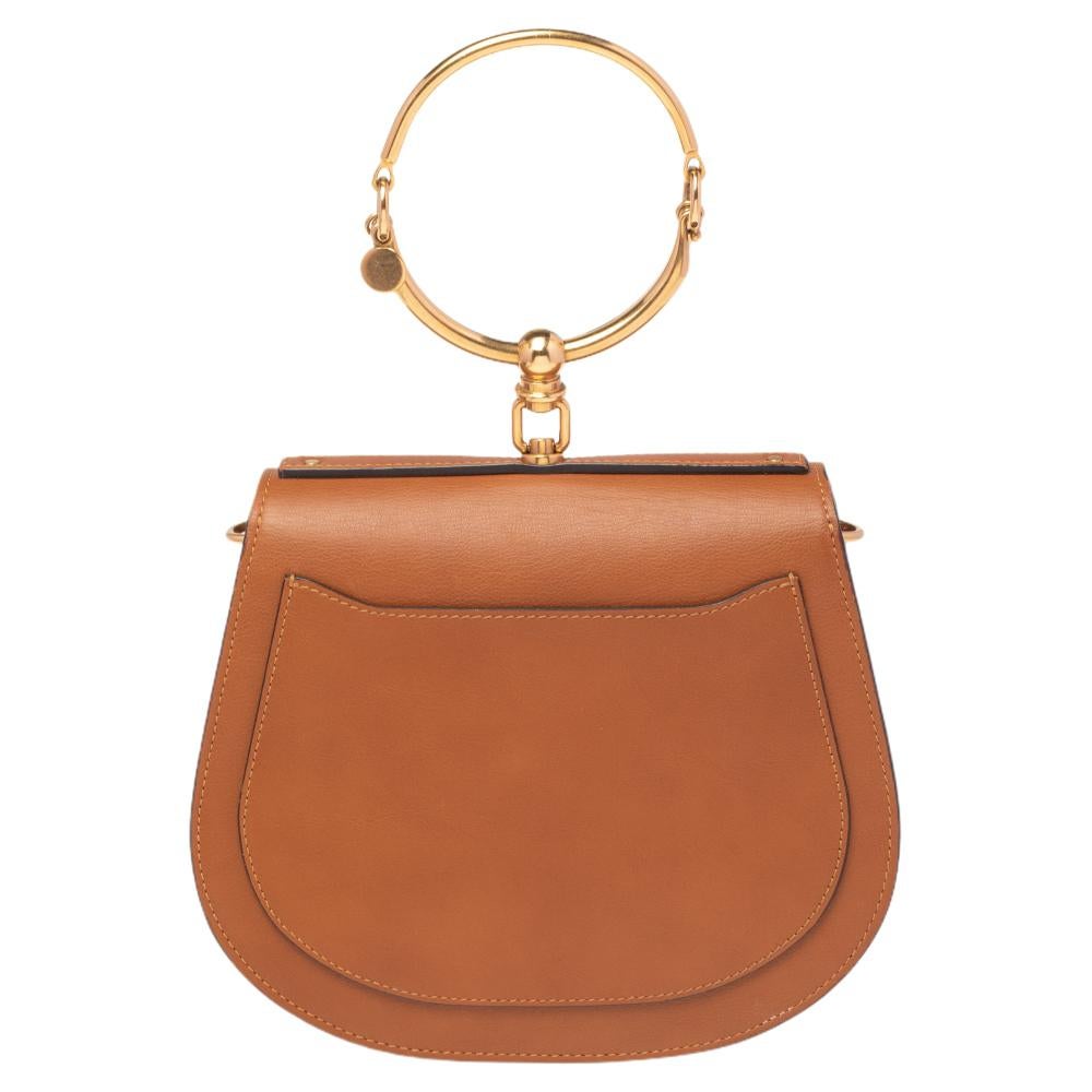 Loved by fashion influencers and celebs, this chic Nile bracelet bag by Chloé will become your most favorite bag, thanks to its unique shape and handle. The creation has been crafted from suede and leather and styled with a front flap. It is