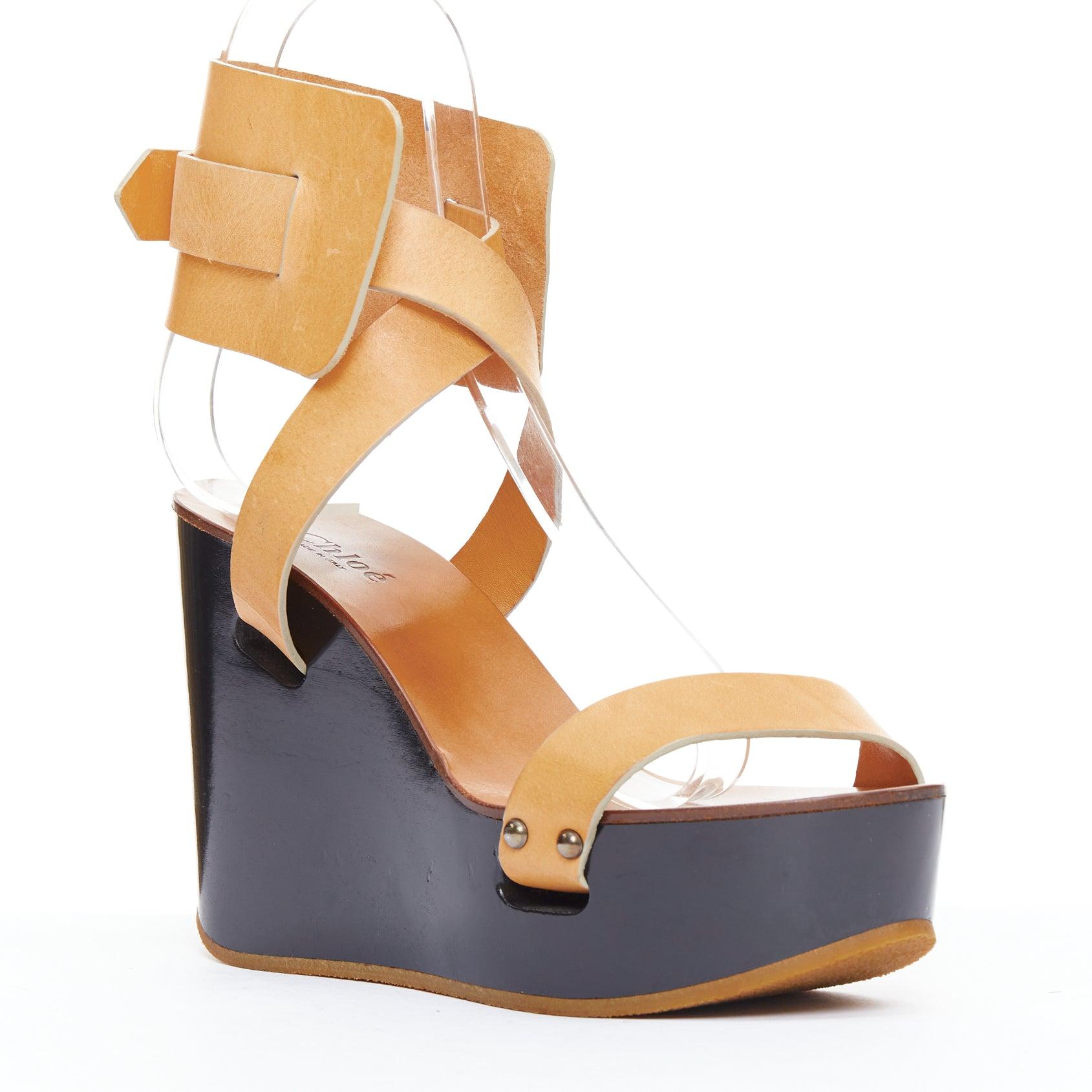 CHLOE tan leather black wooden strappy wedge clog sandals EU36
Reference: ALCU/A00040
Brand: Chloe
Material: Leather, Wood
Color: Brown, Black
Pattern: Solid
Closure: Ankle Strap
Lining: Brown Leather

CONDITION:
Condition: Poor, this item was