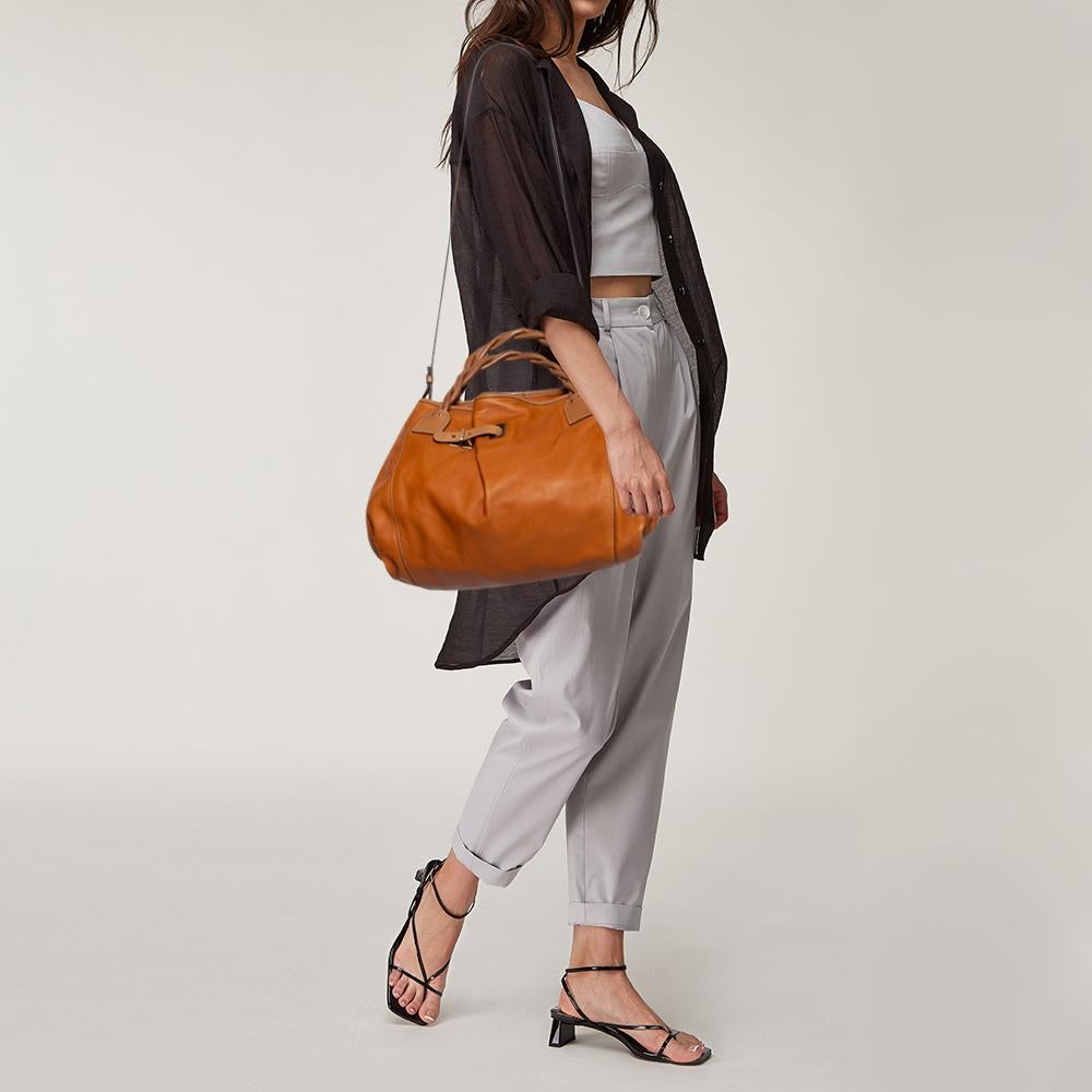 This Chloe creation is a bag that brings joy to one's sight! It has been beautifully crafted from tan leather and designed with a buckled strap detailing at the front, whilst being held by two braided top handles. The bag is also equipped with a