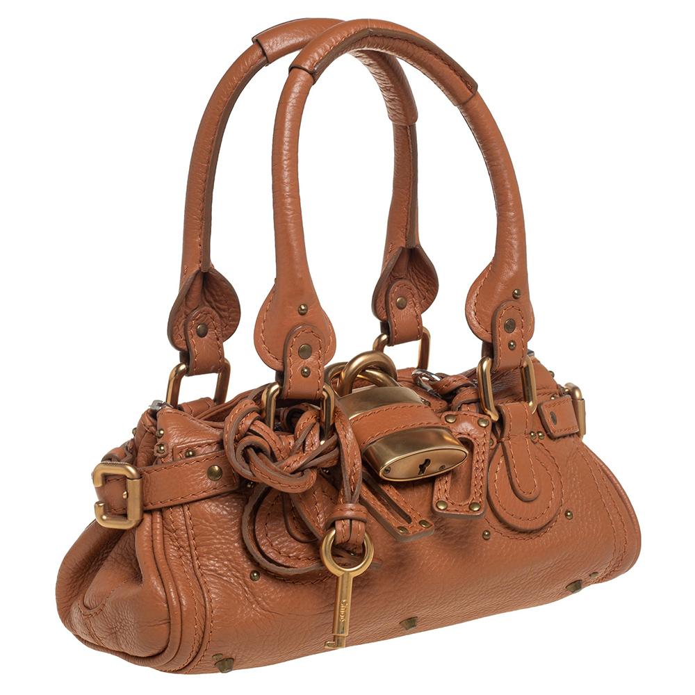 This Chloe Paddington satchel is built to assist your impeccable style on all days. Gold-tone hardware with a chunky lock on the front easily attracts all the attention. The tan leather has an interesting texture while the canvas interior is sized