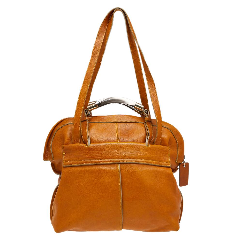An ideal everyday accessory, this Chloe tote is enriched with striking and stylish details. Constructed from tan leather, the exterior has a zipped coin compartment and flap pockets. The design is complete with two short metal & lucite handles, two