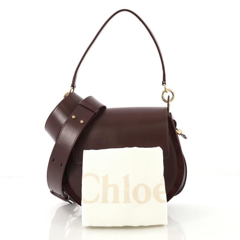 This Chloe Tess Bag Leather Large, crafted from purple leather and suede, features a flat leather handle with rings, slip pocket under flap, ring ornament detail, and gold and silver-tone hardware. Its magnetic snap closure opens to a beige fabric