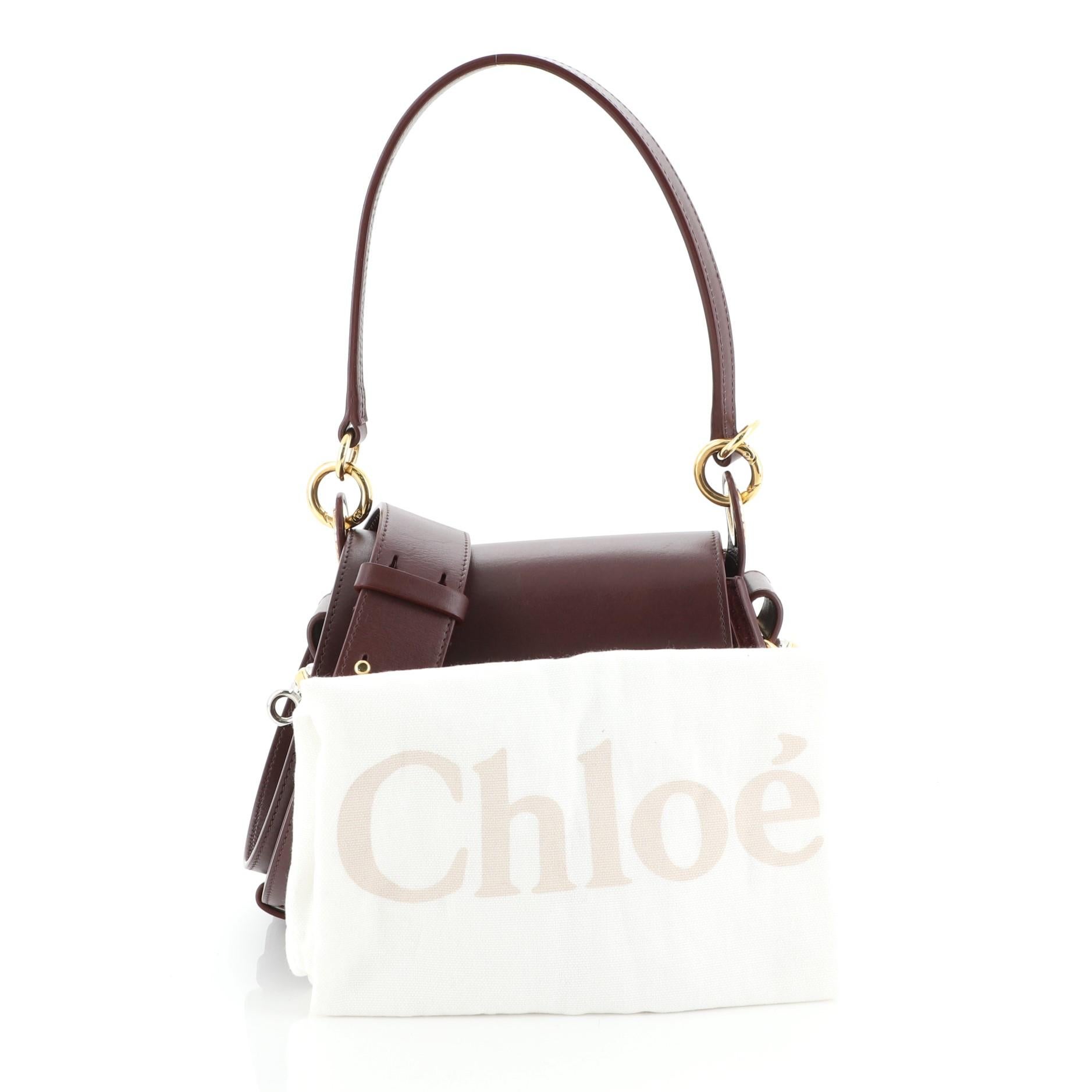 This Chloe Tess Bag Leather Small, crafted from red leather, features a flat leather handle with rings, flat shoulder strap, slip pocket under flap, ring ornament detail, and gold and silver-tone hardware. Its magnetic snap closure opens to a