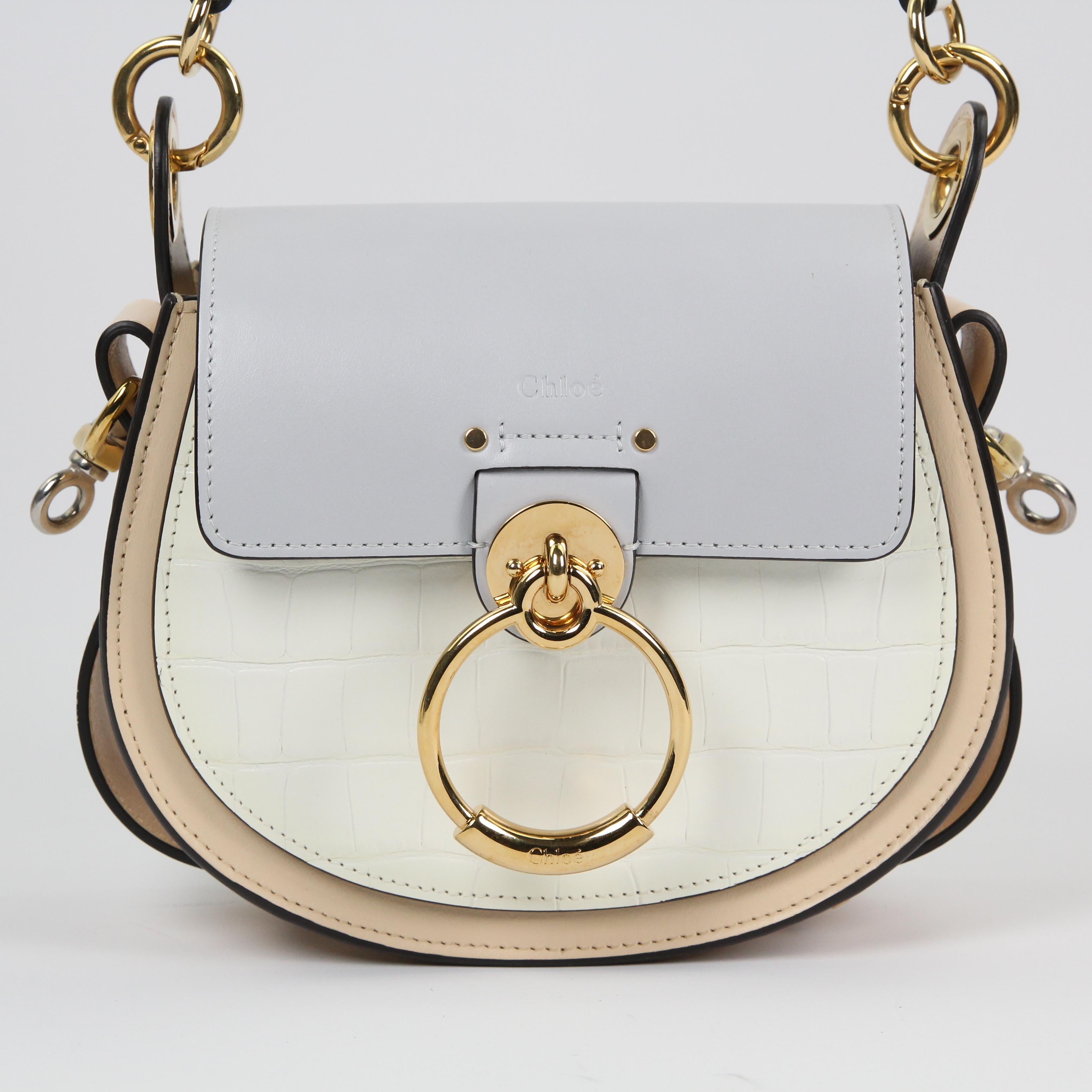 An update on the classic saddle bag, this Chloe Tess bag exudes feminine and pulls from its heritage to create a bag with all bells and whistles that we adore. This chic bag is crafted out of chic leather with a flap closure and a unique ring,