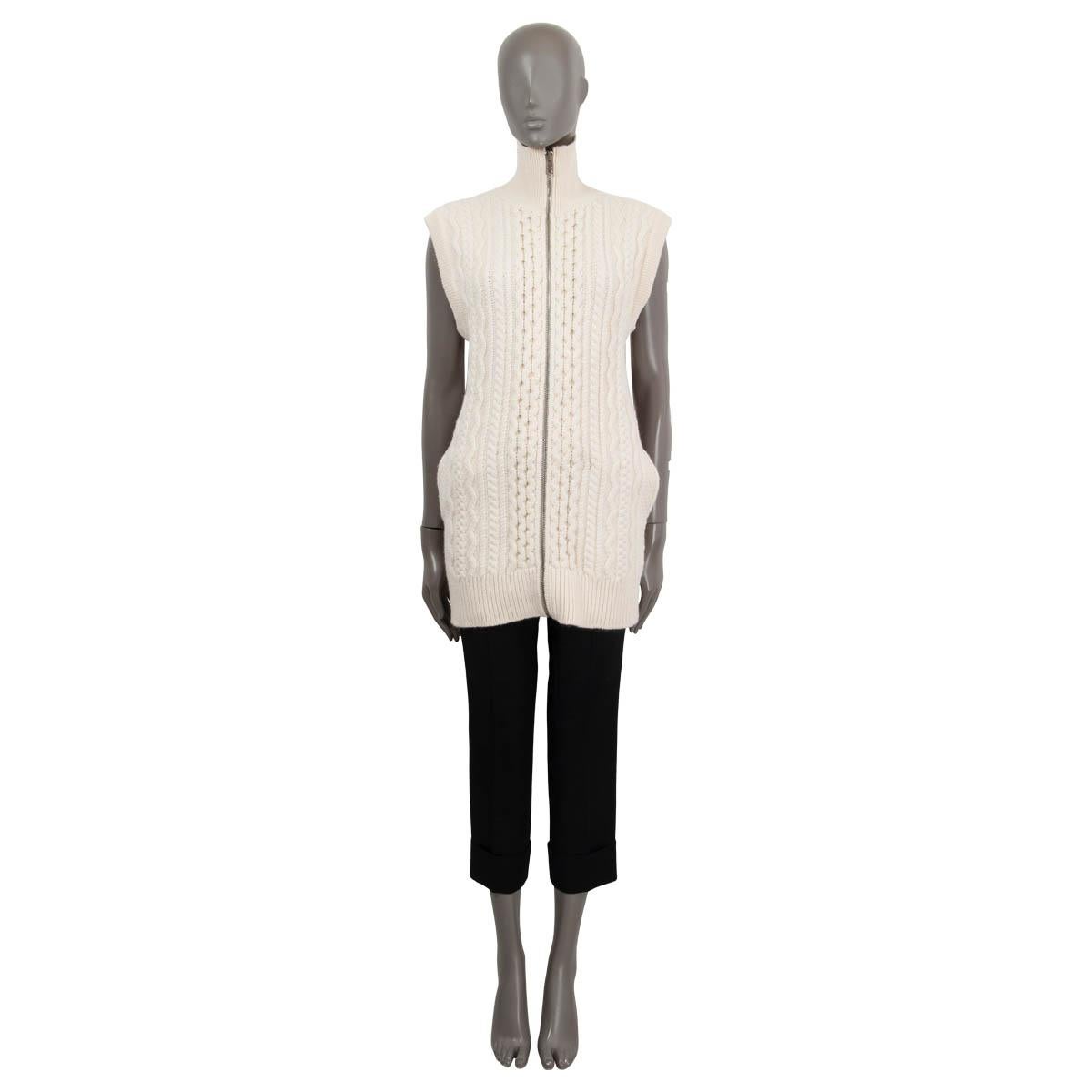 100% authentic Chloé cable kni vest in vanilla ice wool (72%), alpaca (24%) and polyamide (4%) with a technical fabric part on the back in vanilla ice viscose (93%), polyamide (6%) and elastane (1%). Features two side slit pockets and a high neck.
