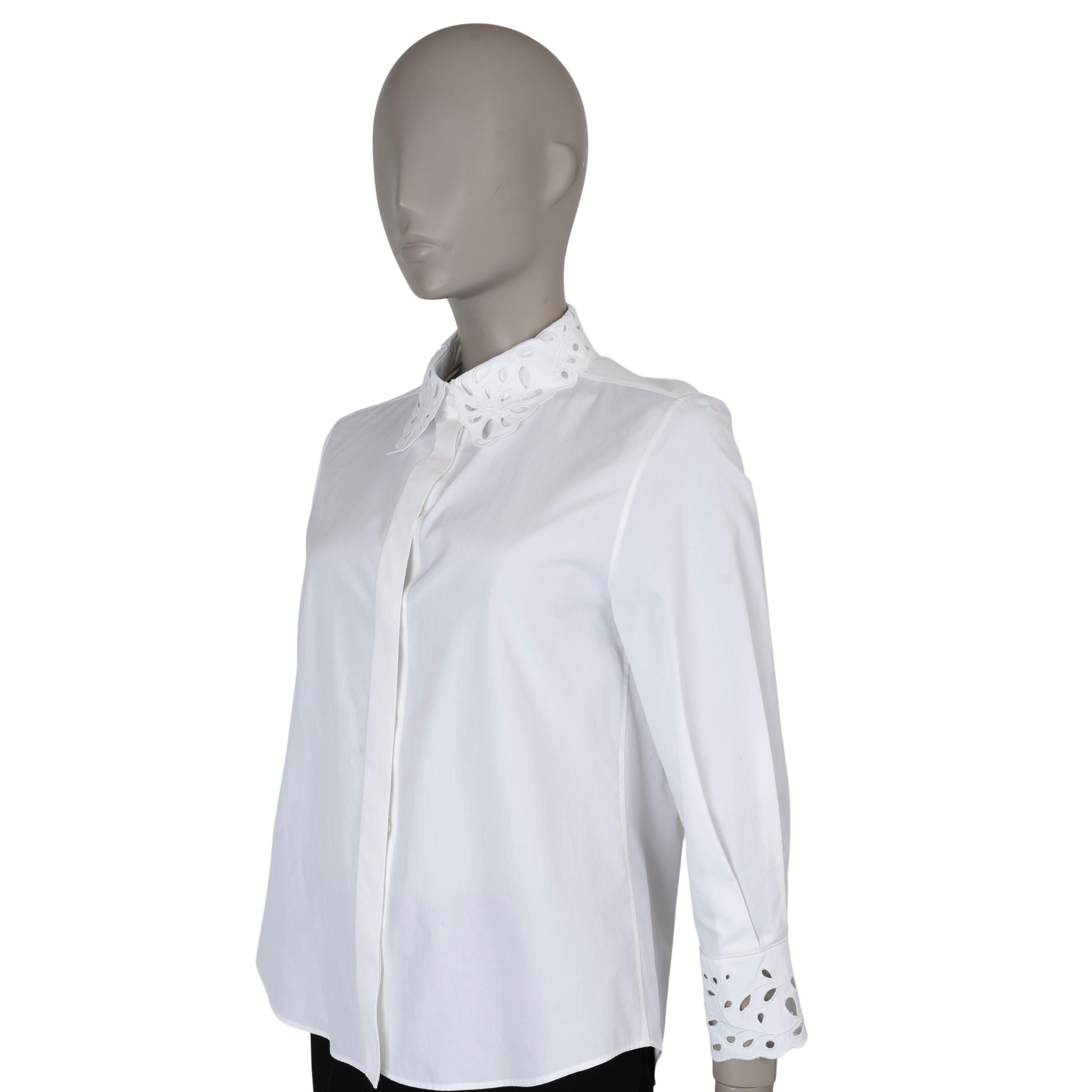 This 100% authentic Chloé button-up shirt in white poplin cotton showcases delicate broderie anglaise detailing on the scalloped point collar and cuffs, adding a refined, feminine touch. It closes with mother-of-pearl buttons hidden under a sleek