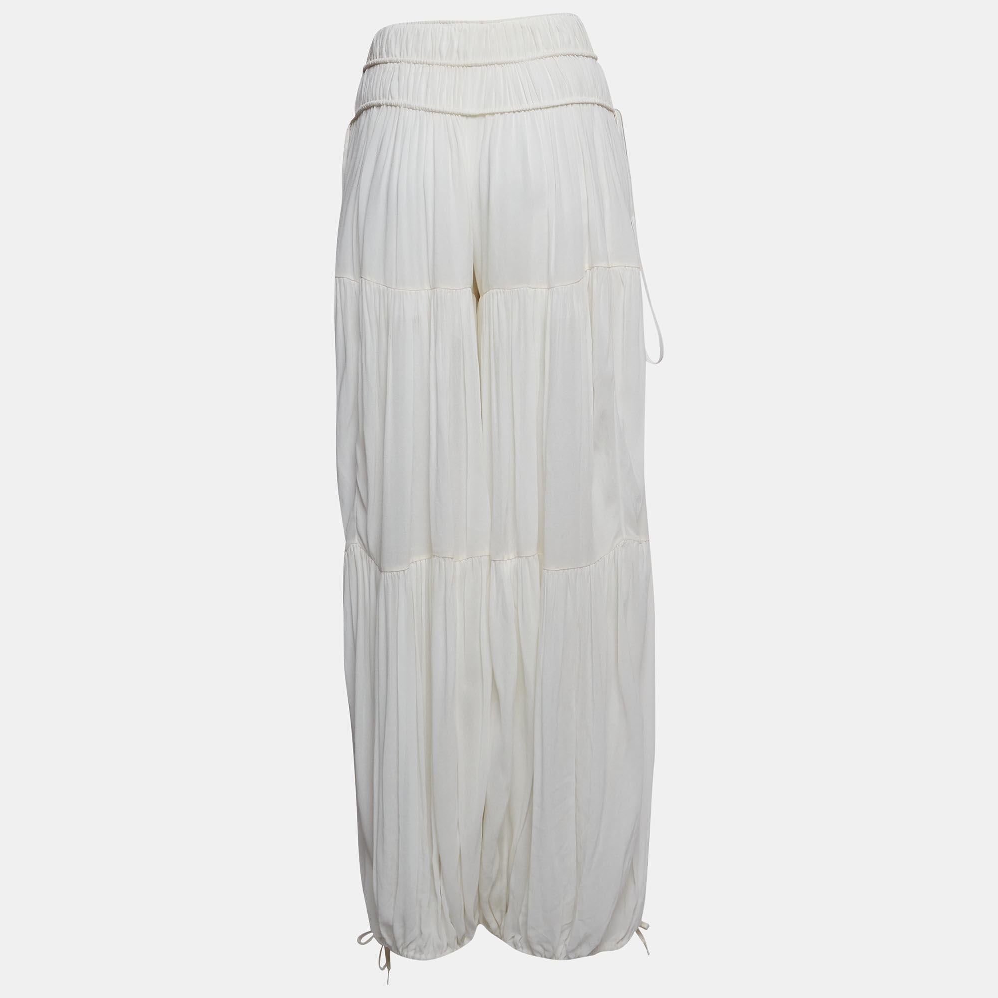 Tailored with finesse, the Chloé harem pants exude effortless charm. Delicately designed from sheer crepe fabric, they boast gathered detailing for a touch of whimsy. Embrace comfort and style with their relaxed harem silhouette, perfect for both