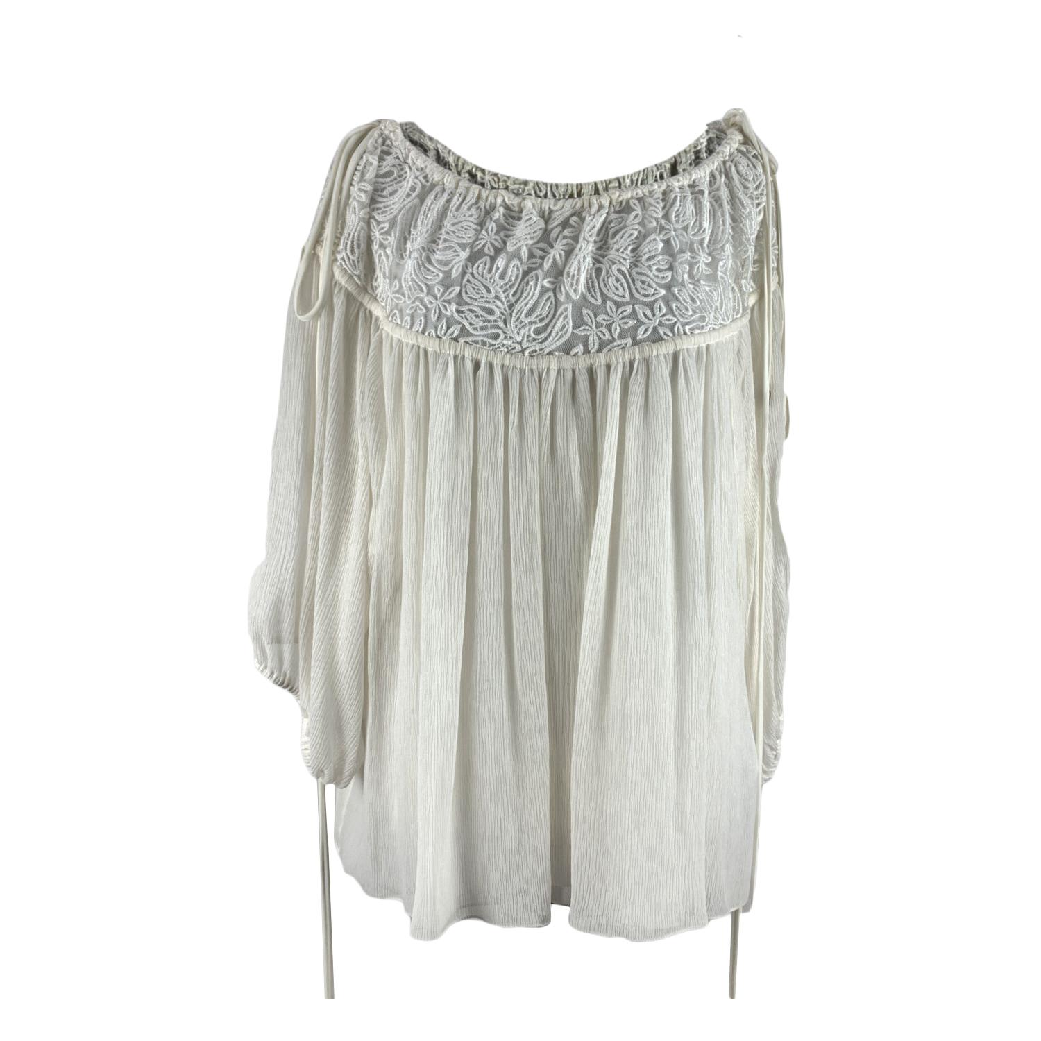 Chloe white oversize blouse in pure silk. Bohemian and romantic style. Round neck with ace trim and drawstring detailing on the neckline. Decorative ties with antiqued gold-tone metal shell-shaped ends. Composition: 100% Silk. Size: 36 FR (it should