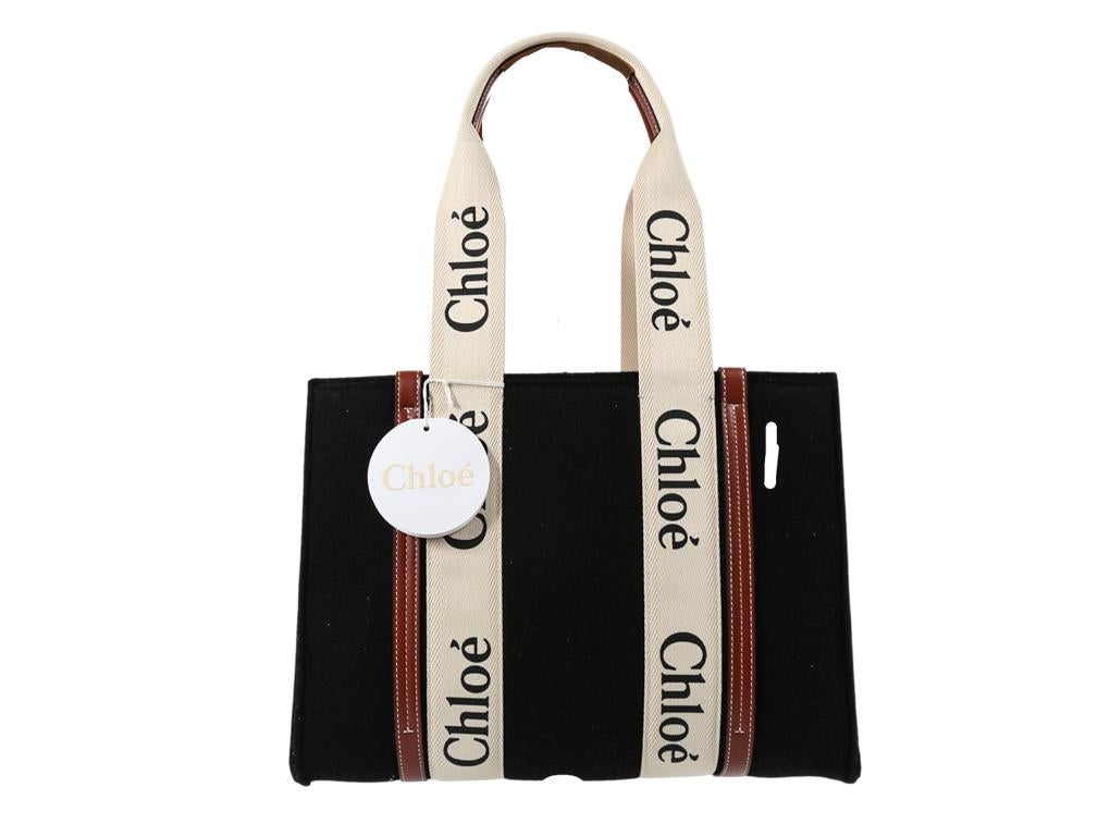 This practical and modern design of Chloé’s black felt Woody tote is offset by tan leather topstitched trims and signature logo tape grosgrain straps. A beautiful bag and this one was purchased, stored and never used.

This item is pre-owned and has