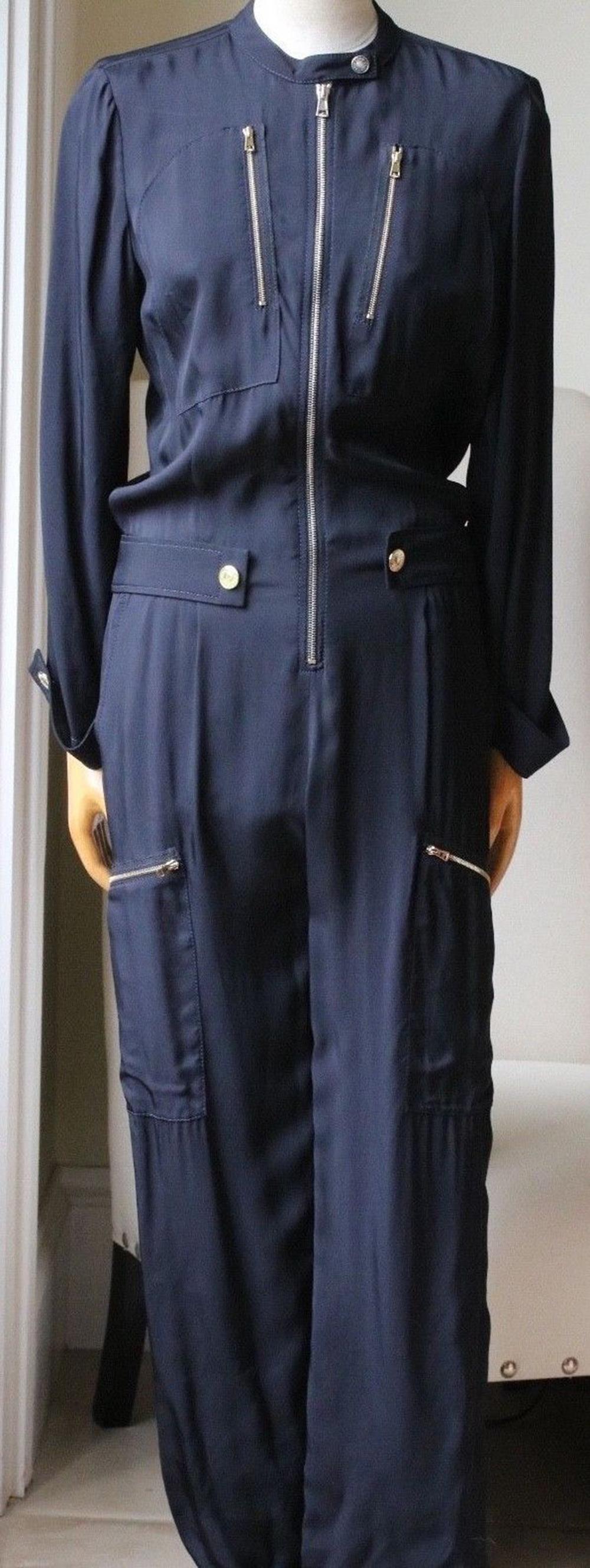 Navy blue silk blend zip front jumpsuit from Chloé featuring a band collar, a press stud fastening, front zipped pockets, long sleeves, button cuffs, a straight leg, side zipped pockets to the legs. 100% Viscose. Contrast: 70% acetate, 3%