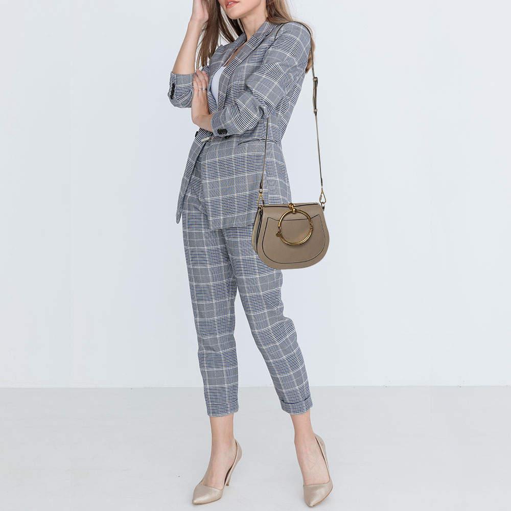 Loved by fashion influencers and celebs this chic Nile bracelet bag by ChloÃ© can become your most favorite bag thanks to its unique shape and handle. The creation has been crafted from suede and leather and styled with a front flap. It is complete