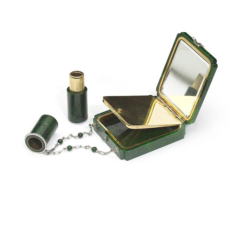 An Art Deco chloromelanite jade, gold and diamond vanity case and lipstick holder by Marchak, the rectangular chloromelanite jade, with curved cut corners and a rose cut diamonds set clasp and hinges, inside is a mirror to one side surrounded by an