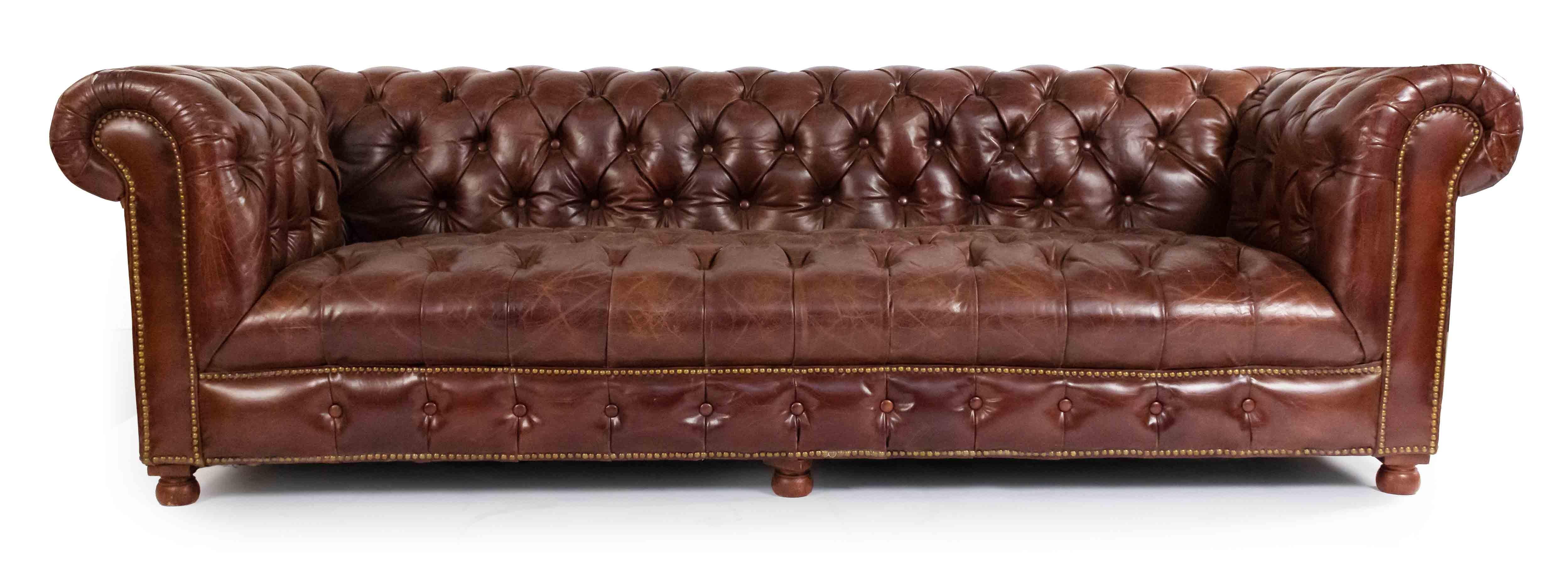English Victorian style chocolate brown tufted leather Chesterfield sofa with distressed finish and out-scrolled arms on four wooden bun feet. Brass rivets along trim.