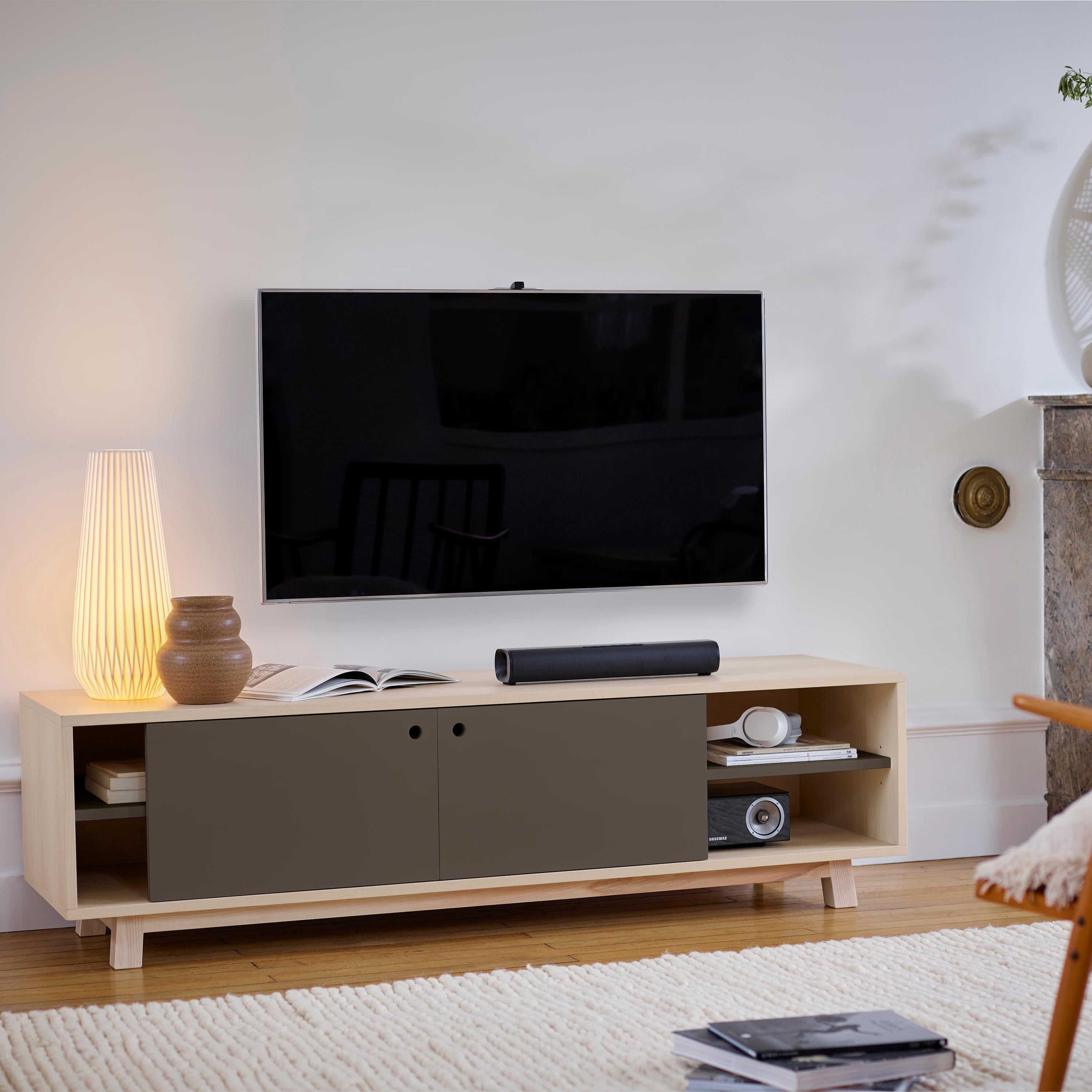 This TV stand with 2 sliding doors is designed by Eric Gizard - Paris.

It is 100% made in France with solid and veneer ash and lacquered MDF doors. 

To pull the door, use the round eyelet. 
2 adjustable wooden shelves on cleats are placed