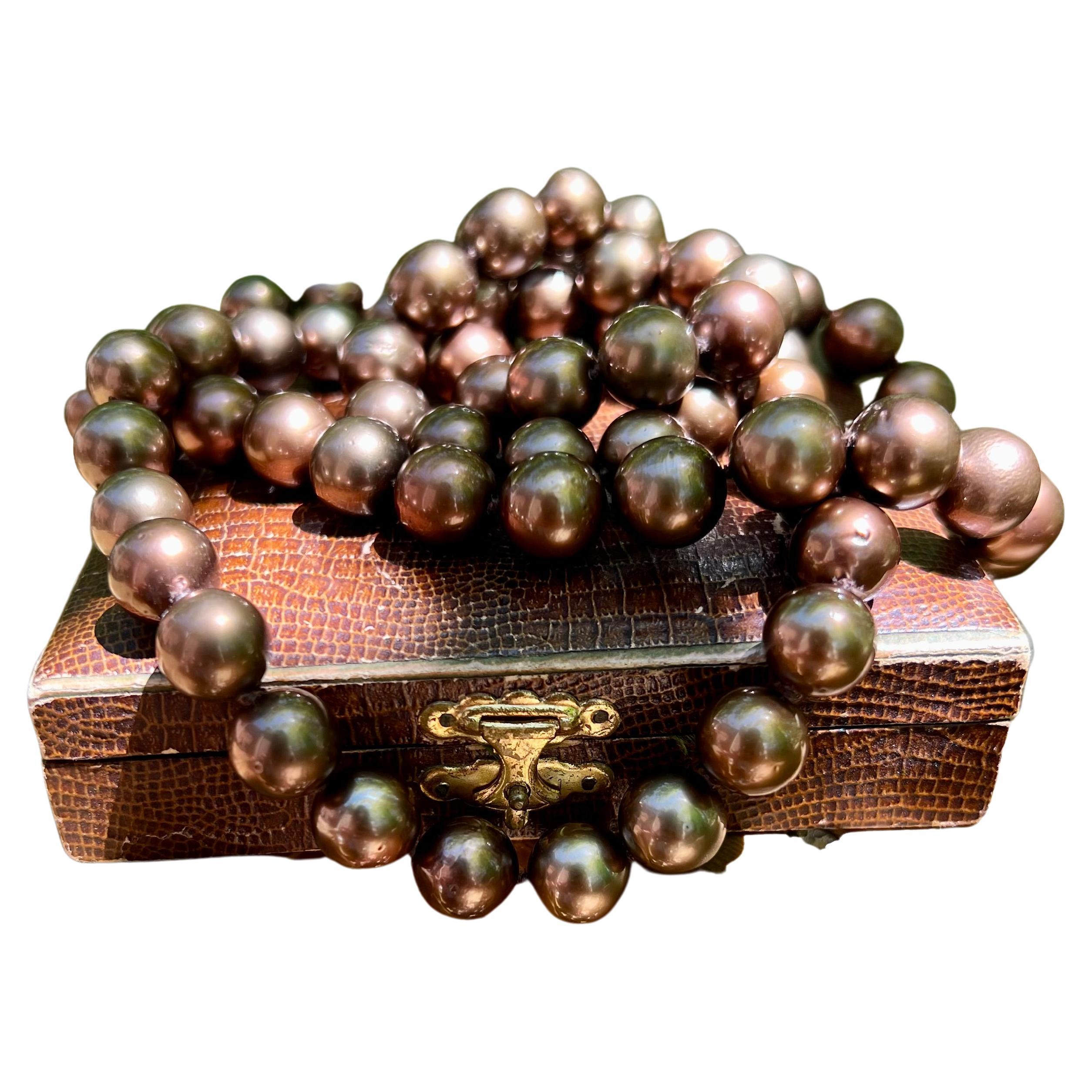 Eine gefärbte schokoladenfarbene Tahiti-Perlenkette mit sechsundsiebzig 11-14,6 mm großen Perlen, die 36 Zoll lang ist und mit einem versteckten Verschluss geschlossen wird.  