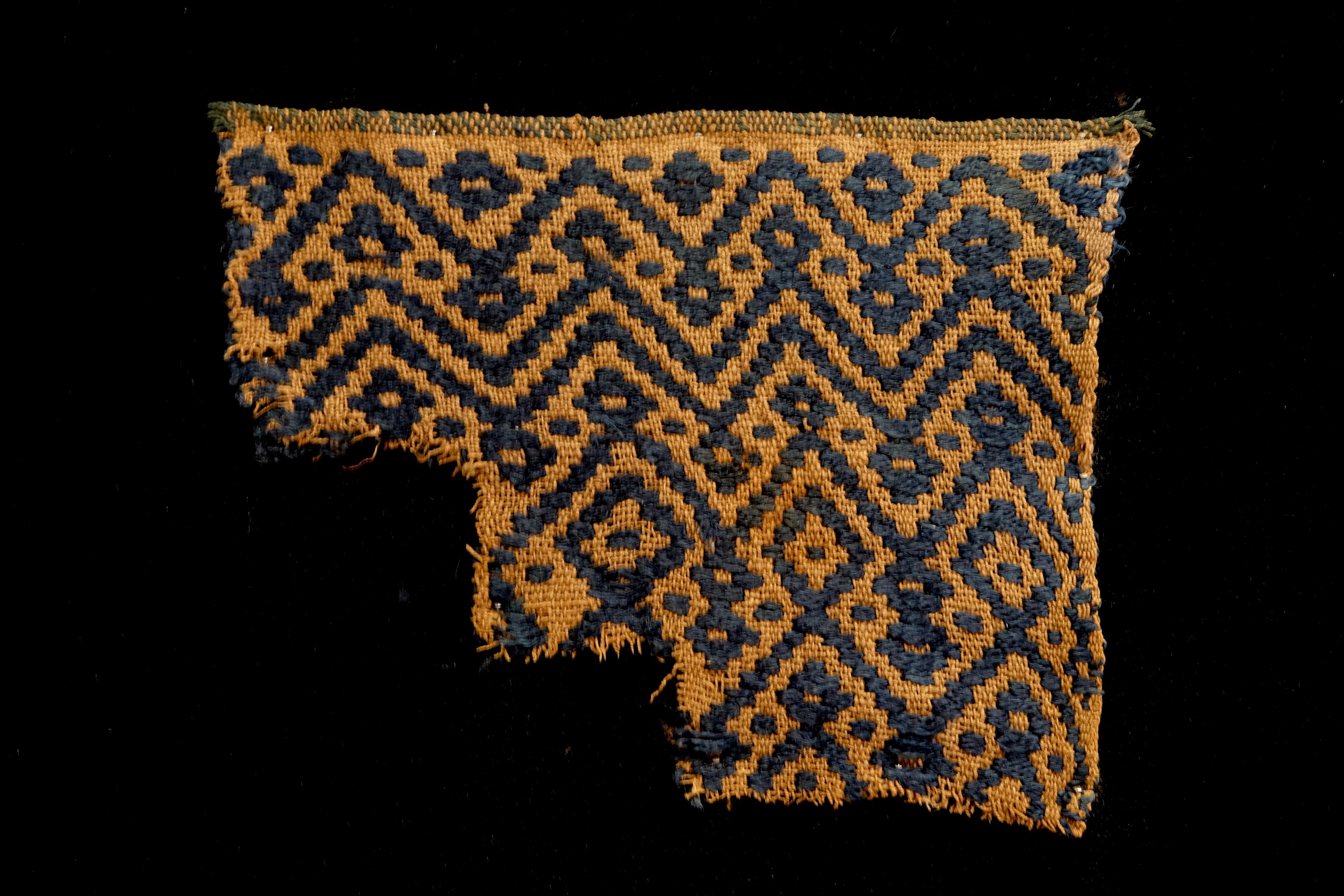 Golden brown Pre-Columbian textile fragment with dark blue geometric patterns. This piece is framed in a black shadowbox.

It is a wonder to behold antiquities such as a Pre-Columbian textiles, an authentic piece of art that has been preserved for