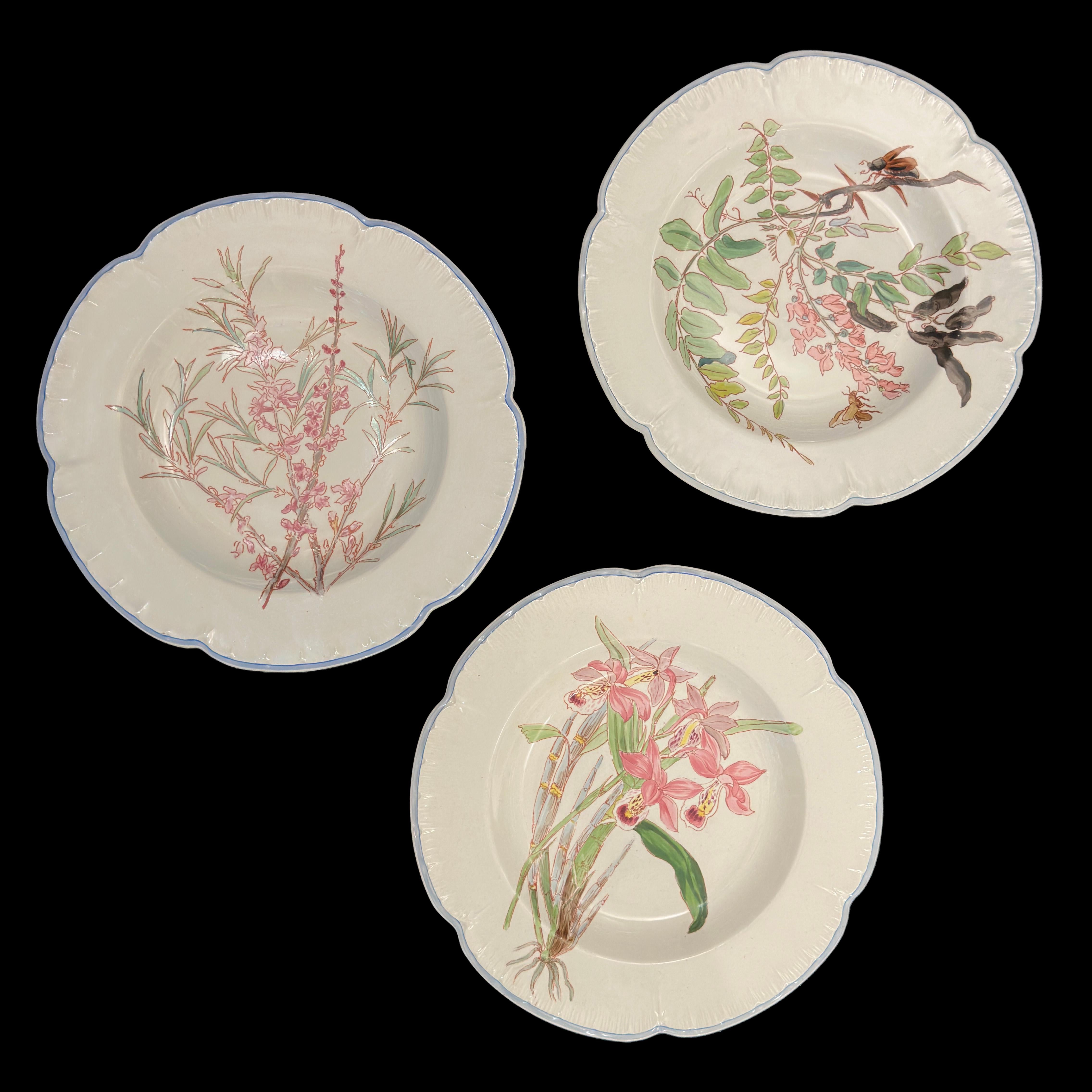 Remarquable service de table en faïence française de la célèbre manufacture de Choisy-le-Roi, vers 1900. Chaque pièce est magnifiquement décorée de motifs botaniques peints à la main en polychromie naturaliste, mettant en évidence le raffinement