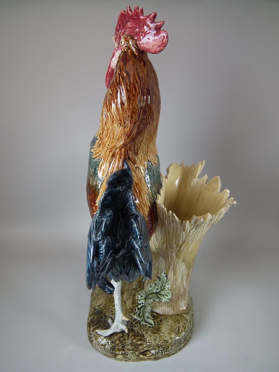 Choisy Majolica vase which features a rooster stood in front of a stone wall. Signed, 'LOUIS CARRIER-BELLEUSE' to the side of the base. Coloration: Brown, blue, dark pink, are predominant. The piece bears maker's marks for the Choisy pottery. Bears