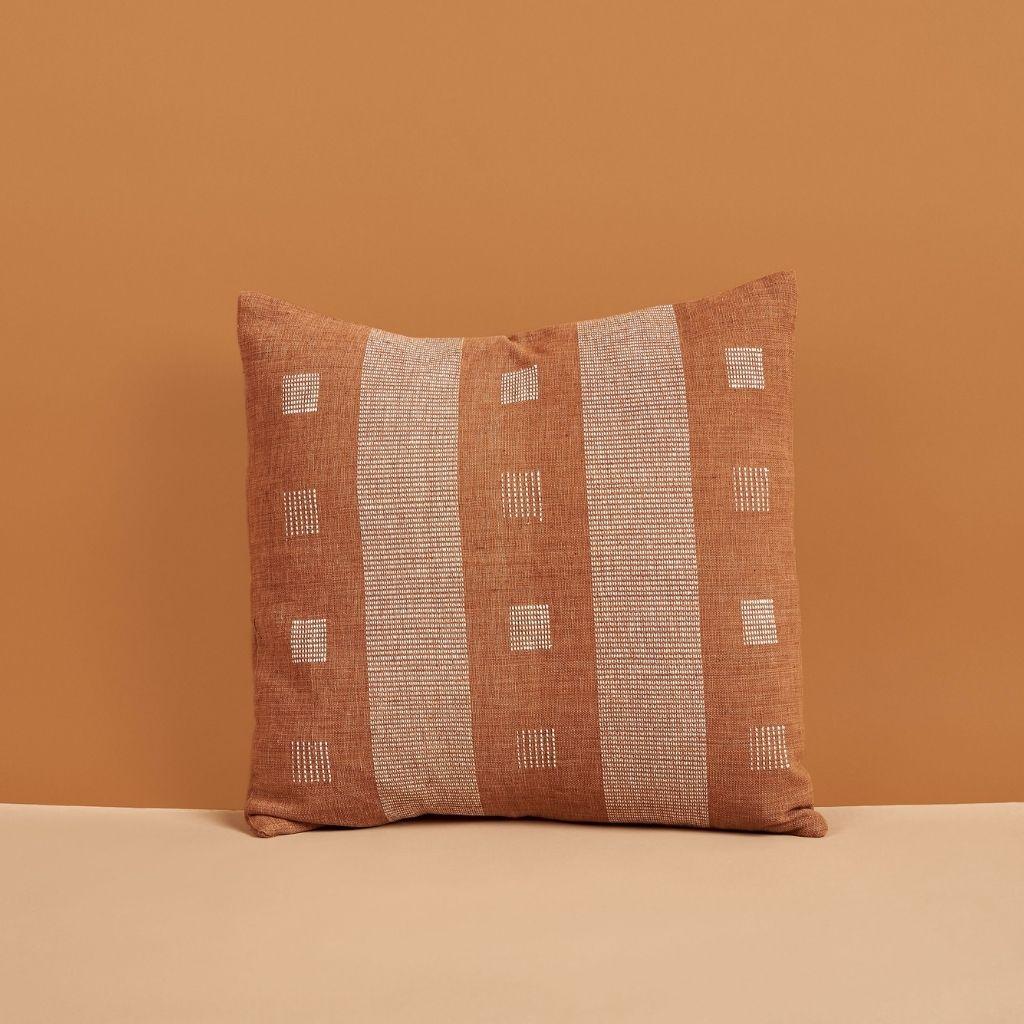 Chokor Nira Brown Pillow is a slightly textured handwoven pillow where our artisans have skillfully created a classic pattern using an ancient weaving technique. Undyed yarn is used as a design element with the backdrop of pleasant hues of