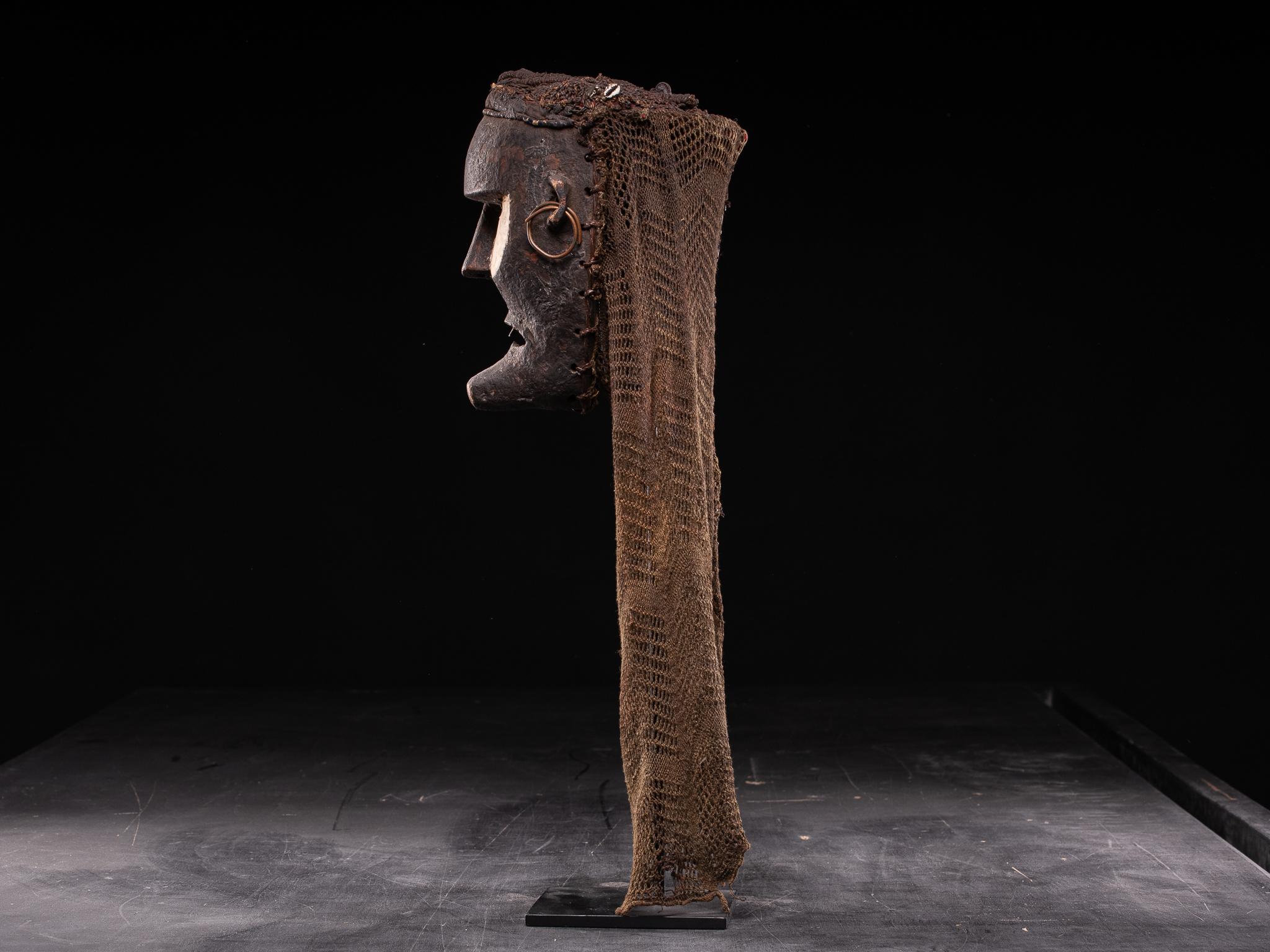 This unusual Chokwe mask is probably of the Katoyo type, representing non-Chokwe individuals. The deviation of the mask from the more common Chokwe masks is due largely to the fact that they represent Portuguese or European features: a long