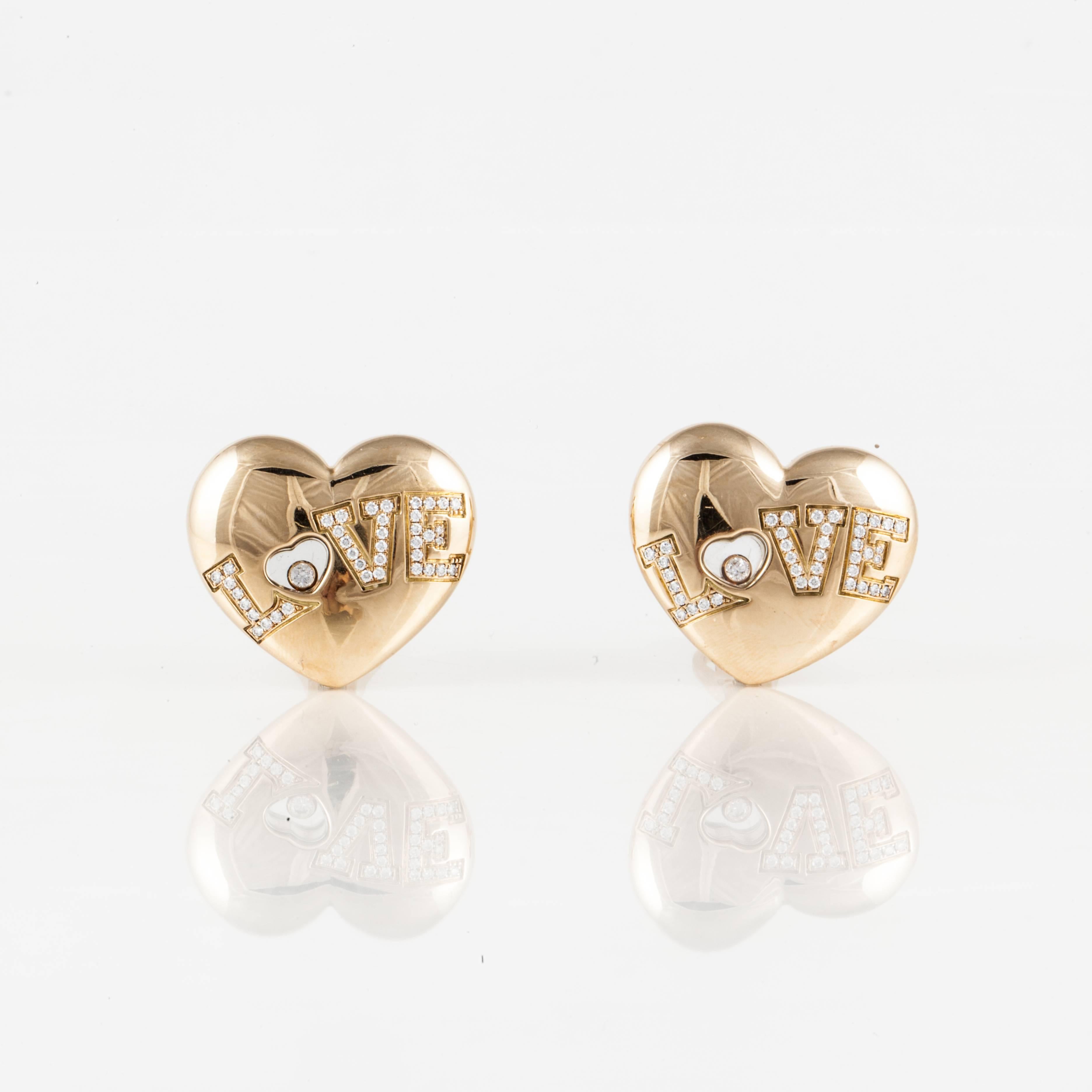 Pair of Happy Diamonds Love earrings by Chopard.  They are numbered:  84/2899-20 9853409.  Heart shaped with LOVE spelled out in round diamonds.  There are 80 round diamonds totaling 0.90 carats; G-H color and VVS-VS clarity.  Earrings measure 7/8