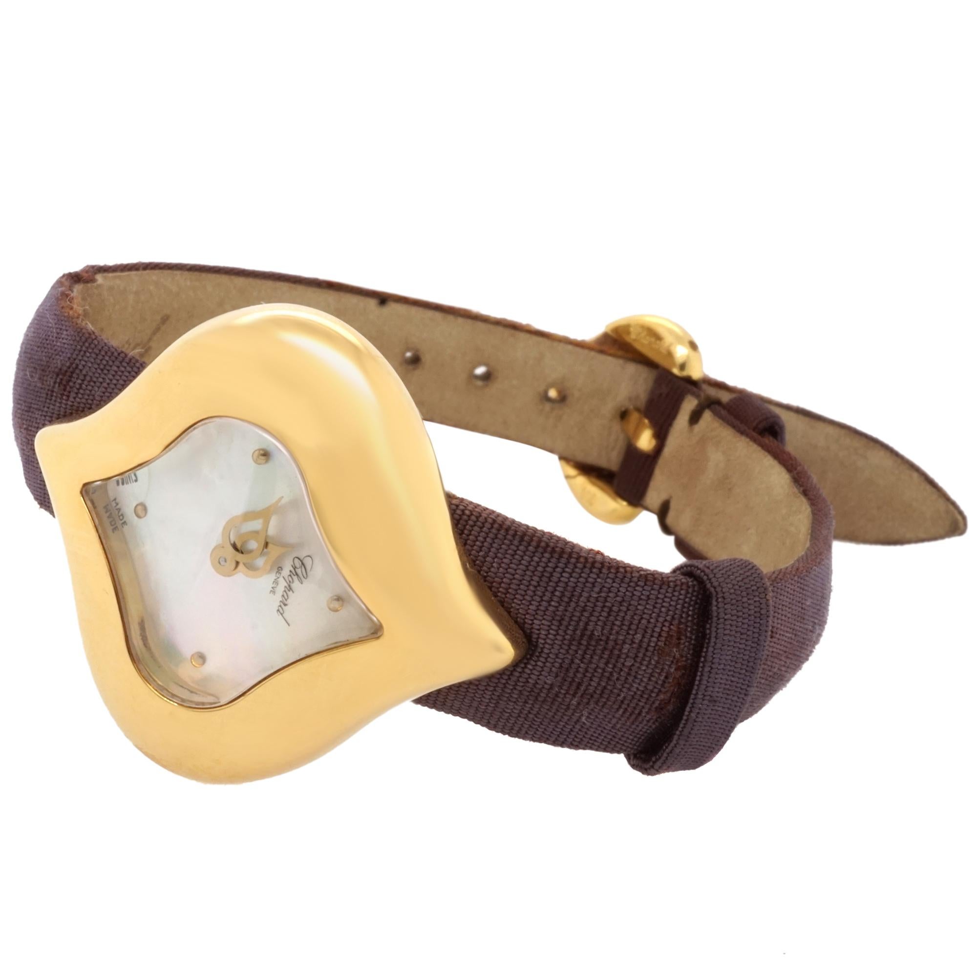Montre-bracelet Chopard en or jaune 18 carats avec cadran en nacre, signée Chopard Swiss Made. Le bracelet est en tissu marron foncé et violet, soutenu par du cuir estampillé Chopard au verso.  Fermé par un fermoir en or jaune 18 carats Signé