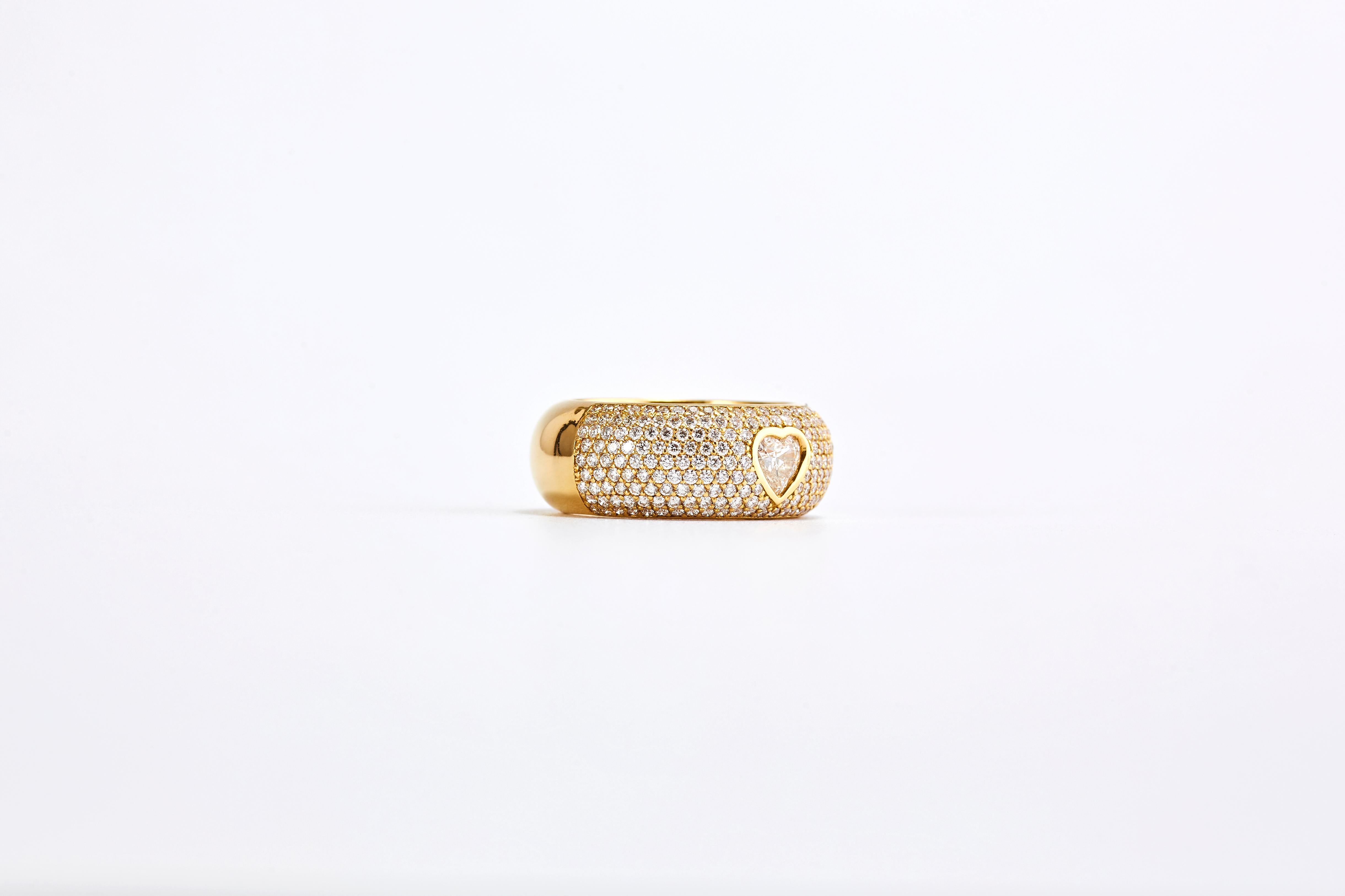 Chopard 18 Karat Yellow Gold Happy Diamond Heart Cut Diamond Ring

Amazing Chopard Yellow Gold and Diamonds Band Ring. 
The center diamond is a 0.75 carat  F VS1 heart cut diamond. On either side of the heart are 9 rows of 2.70 carat F VS1 of fine