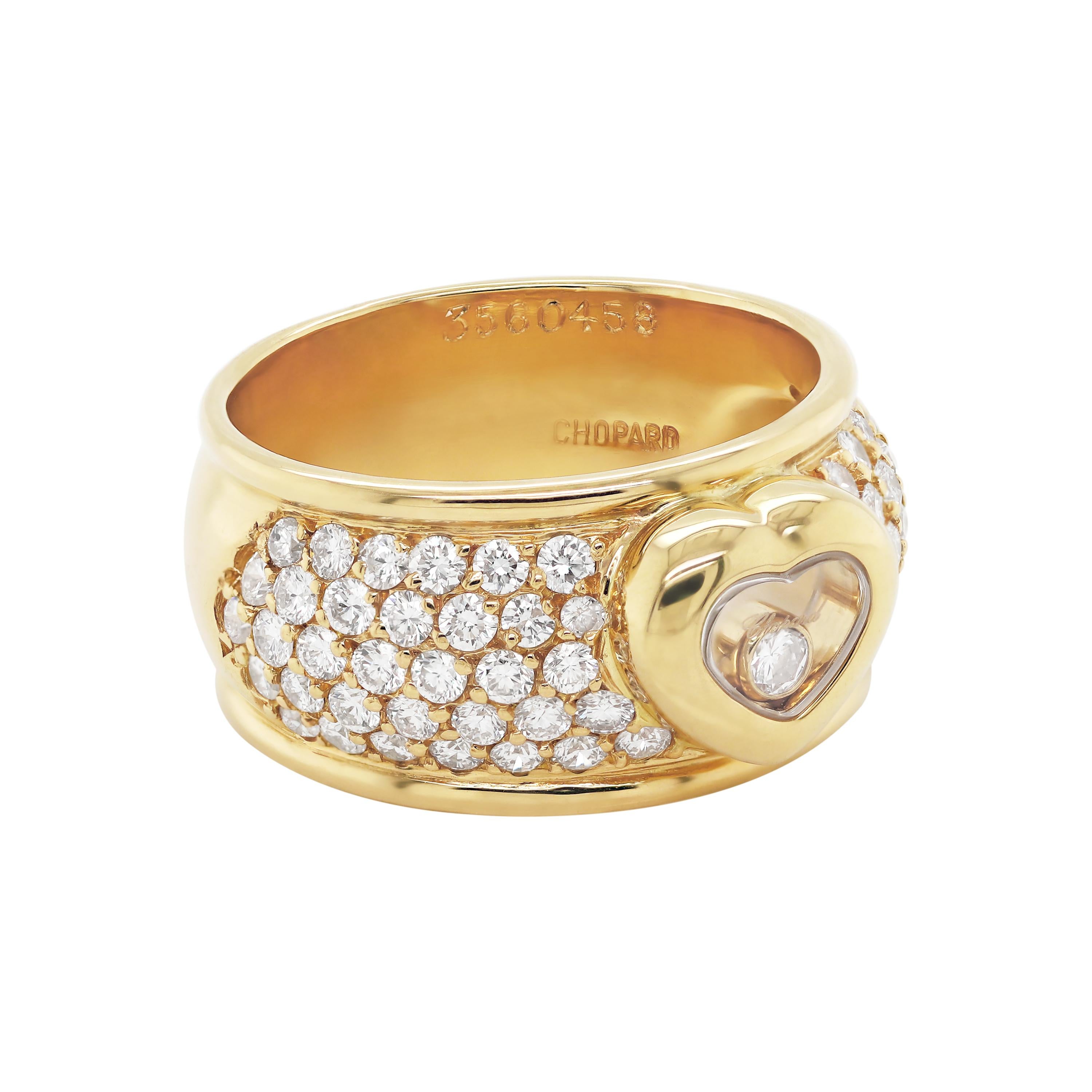 This beautiful ring created by Swedish designer, Chopard is from their signature Happy Diamonds collection. The ring features a freely moving round brilliant cut diamond encased in a yellow gold heart shaped mount. On either side of the heart are 5