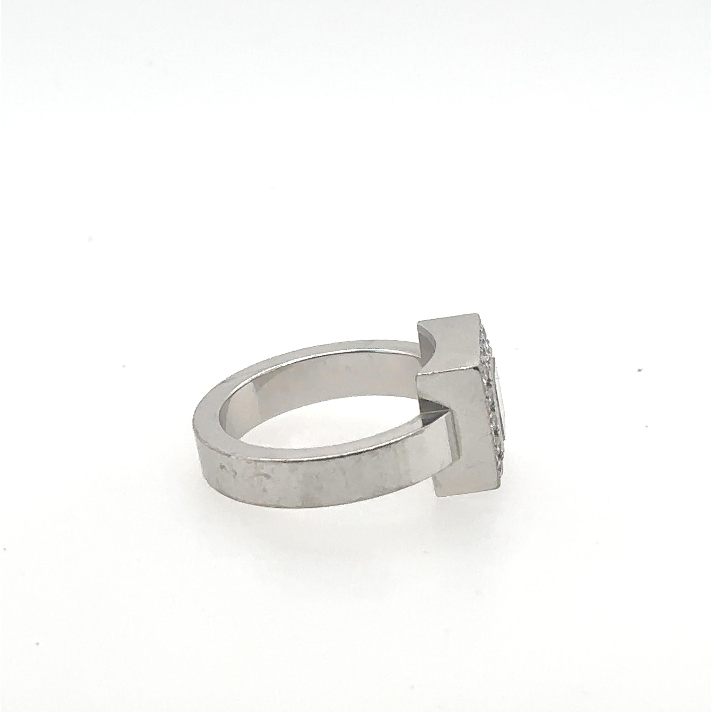Chopard Happy Diamonds Ring.
18 Karat Weißgold.
Ca. 16 Diamanten umgeben das äußere Quadrat mit einem schwebenden Solitärdiamanten in der Mitte.
Auf dem Innenband eingraviert: Chopard, 750 und Seriennummer.
