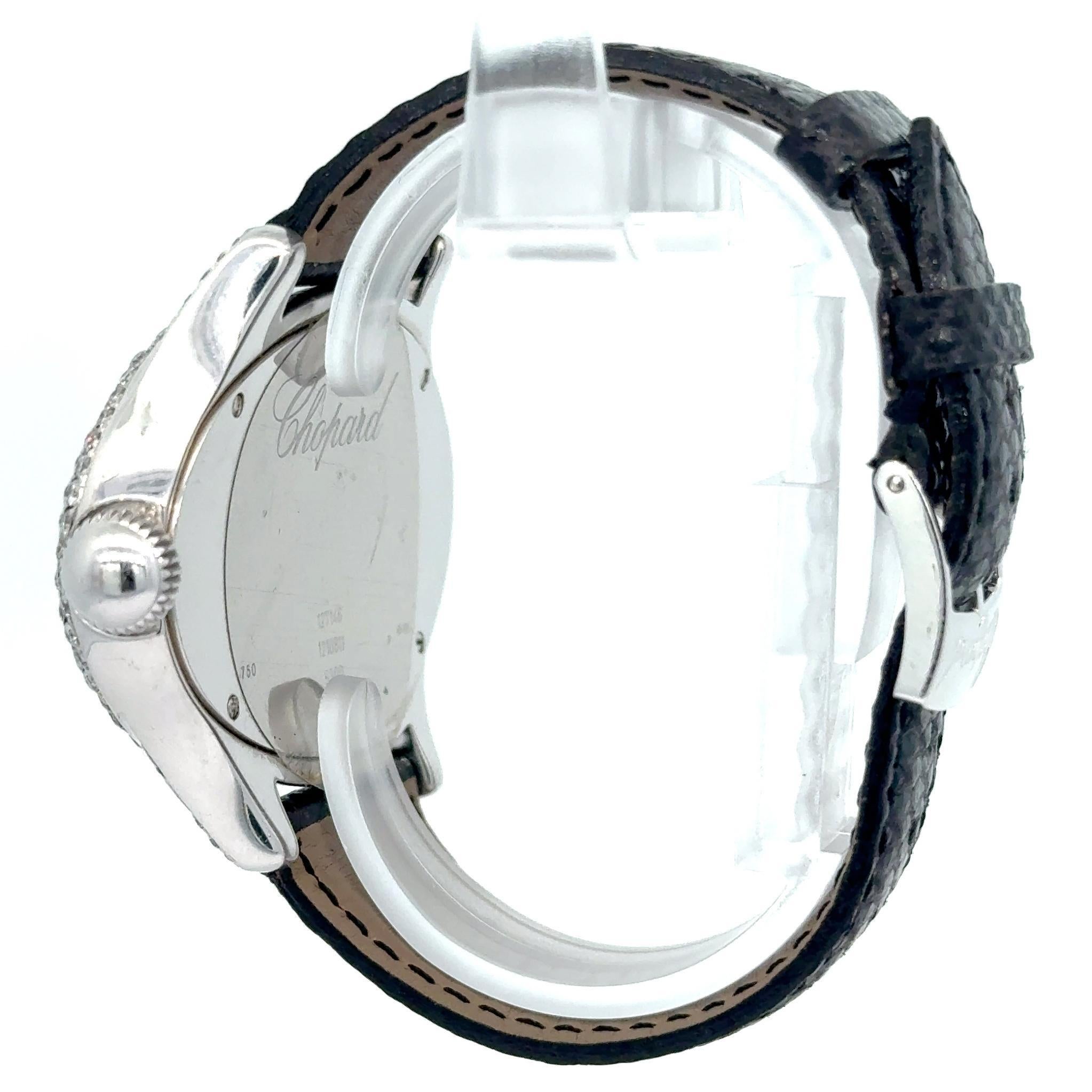 Le modèle 127146 de Chopard est un luxueux garde-temps féminin doté d'un élégant boîtier ovale en or blanc 18 carats, entièrement serti de diamants taille brillant. Son cadran pavé de diamants présente des chiffres romains surdimensionnés et un