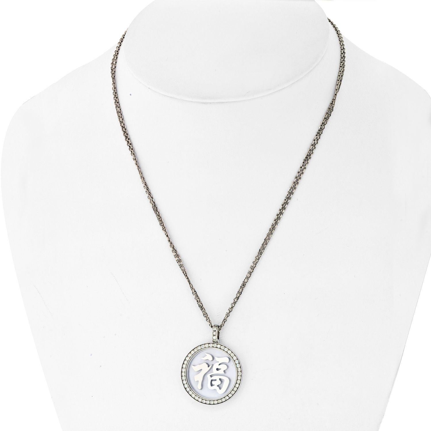 This Contemporary Chopard 18k White Gold Pendant Necklace Features 2 White Gold Chains Holding A Chinese Character Symbolizing Good Fortune.
Surrounded By Diamonds (0.67ct Twd). 
The Decoration Size Is 27x27mm. 
The Length Is 16.5 Inches. 
The Total