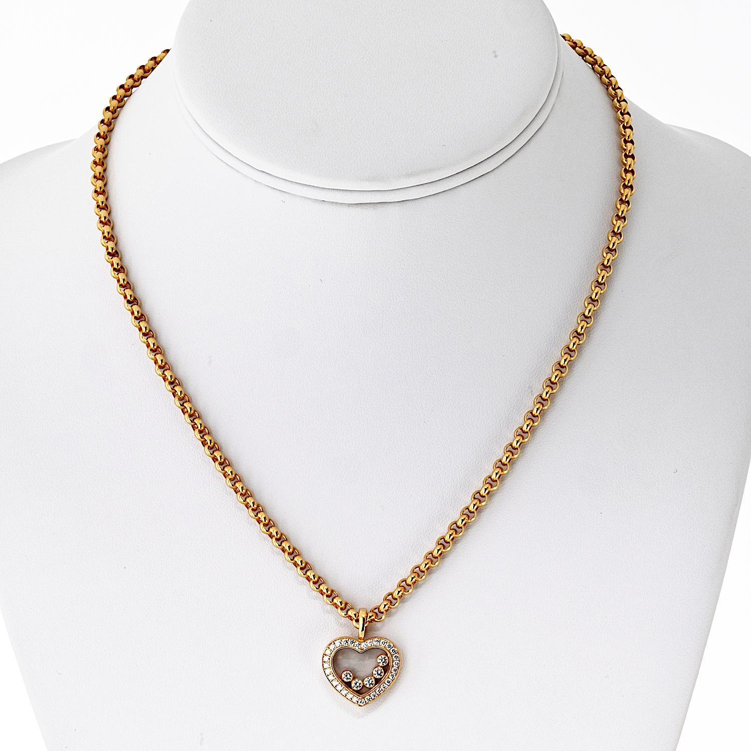 Diese zeitlose Kreation von Chopard aus 18 Karat Gelbgold zeigt den ikonischen Happy Diamonds Herzanhänger mit fünf schwebenden Diamanten, die frei zwischen Saphirkristallen tanzen. Der Anhänger ist mit einem zarten Halo aus runden Brillanten in