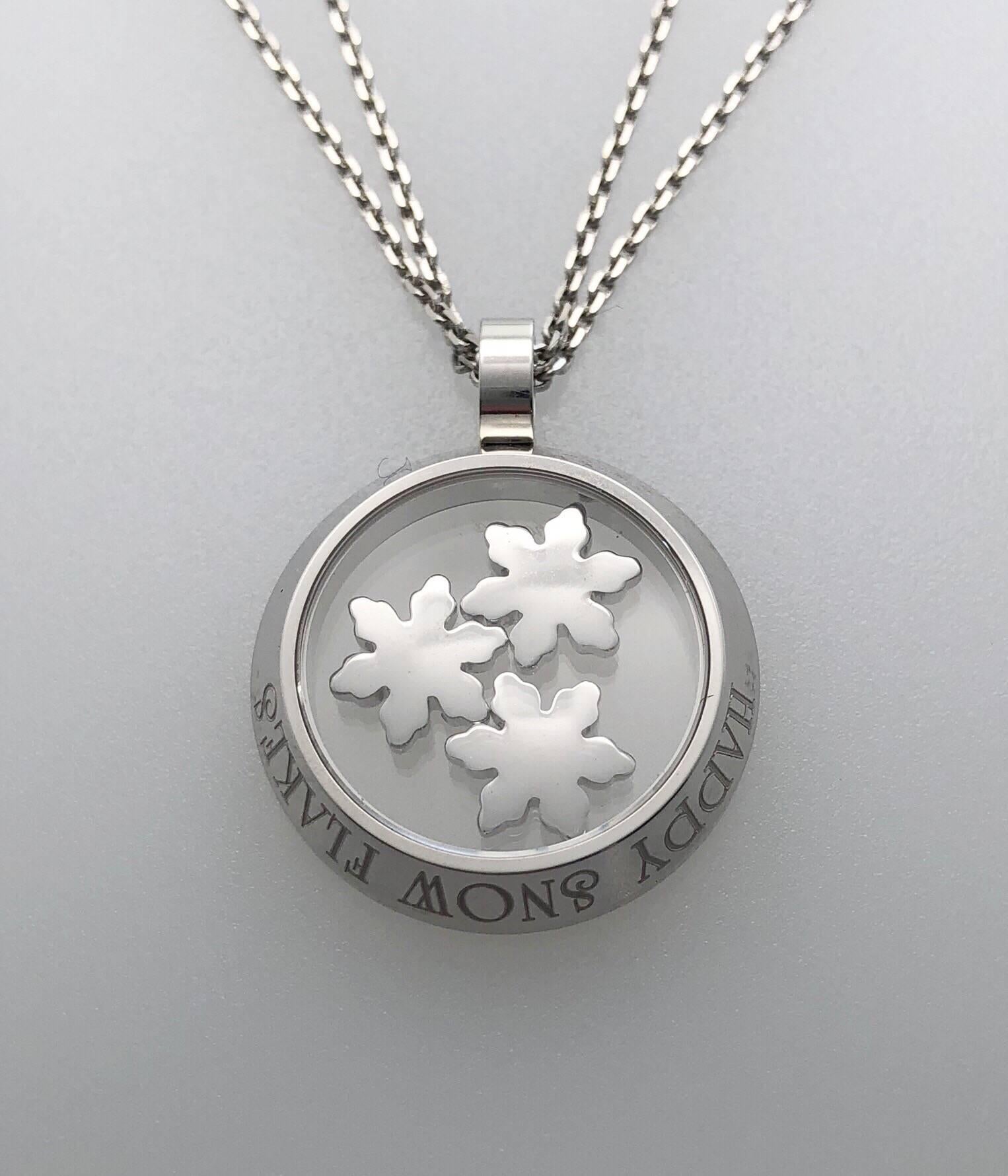 Set in 18 karat white gold, This stunning iconic Happy Snow Flakes Chopard pendant is composed of a total of .96 carats of F/G color, VS Clarity, Diamonds. There are diamonds on the three floating snowflakes, and on the pendants bezel and bale.