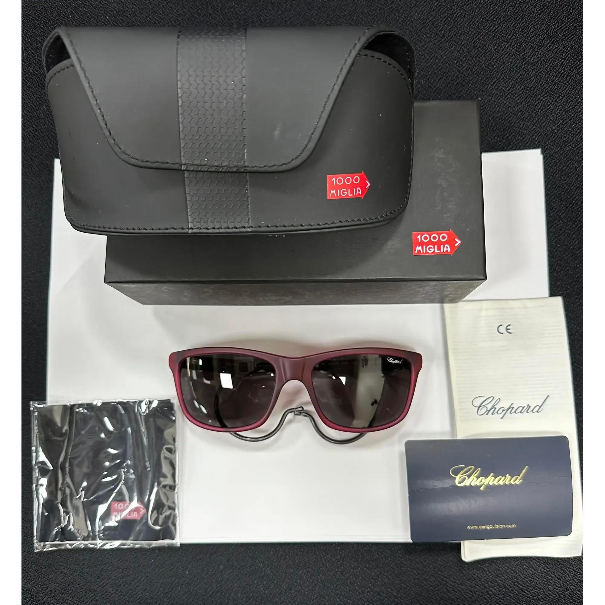 Introducing the luxury unisex Chopard Sunglasses 95221-0275, perfect for street fashion. These sunglasses showcase a claret transparent acetate frame with brushed bakelite color temples and smoke polarized lenses. The arms are elegantly adorned with