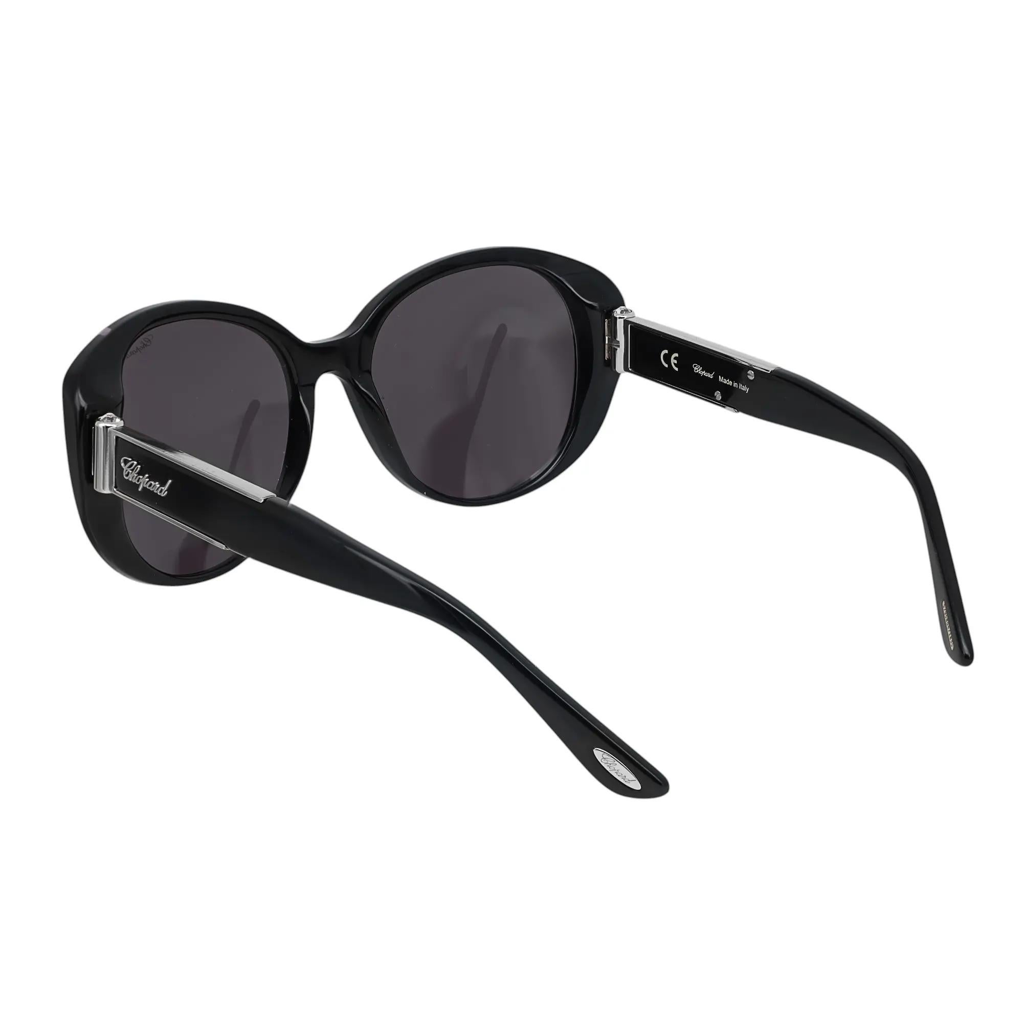 Presenting the luxury unisex Chopard Sunglasses 95221-0230, ideal for street fashion. These sunglasses feature a black acetate claret frame with Gr. lenses. The arms are adorned with the Chopard logo. The dimensions are as follows: Arm Length: 5.2