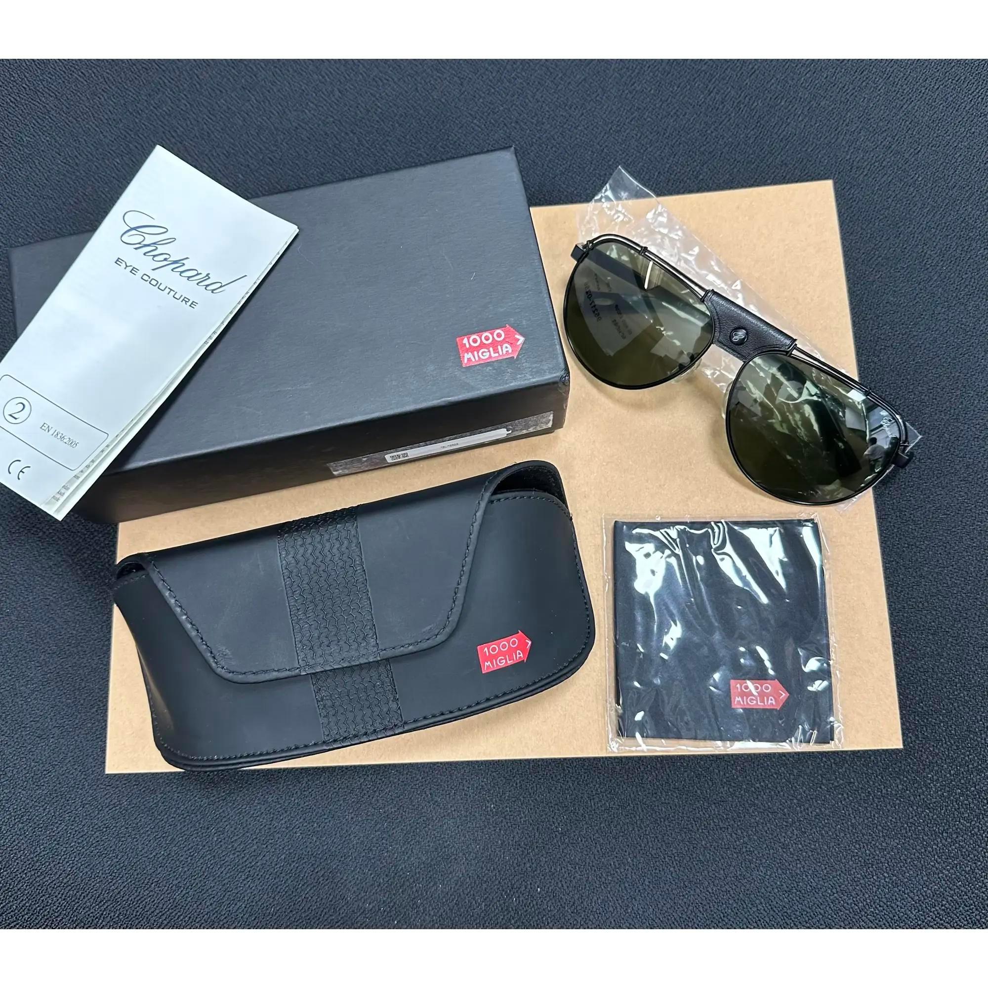 Presenting the luxury unisex Chopard Sunglasses 95221-0256, ideal for street fashion. These sunglasses feature a black color with black temple titanium frame with grey/green polarized lenses. The arms are adorned with the Chopard logo. The