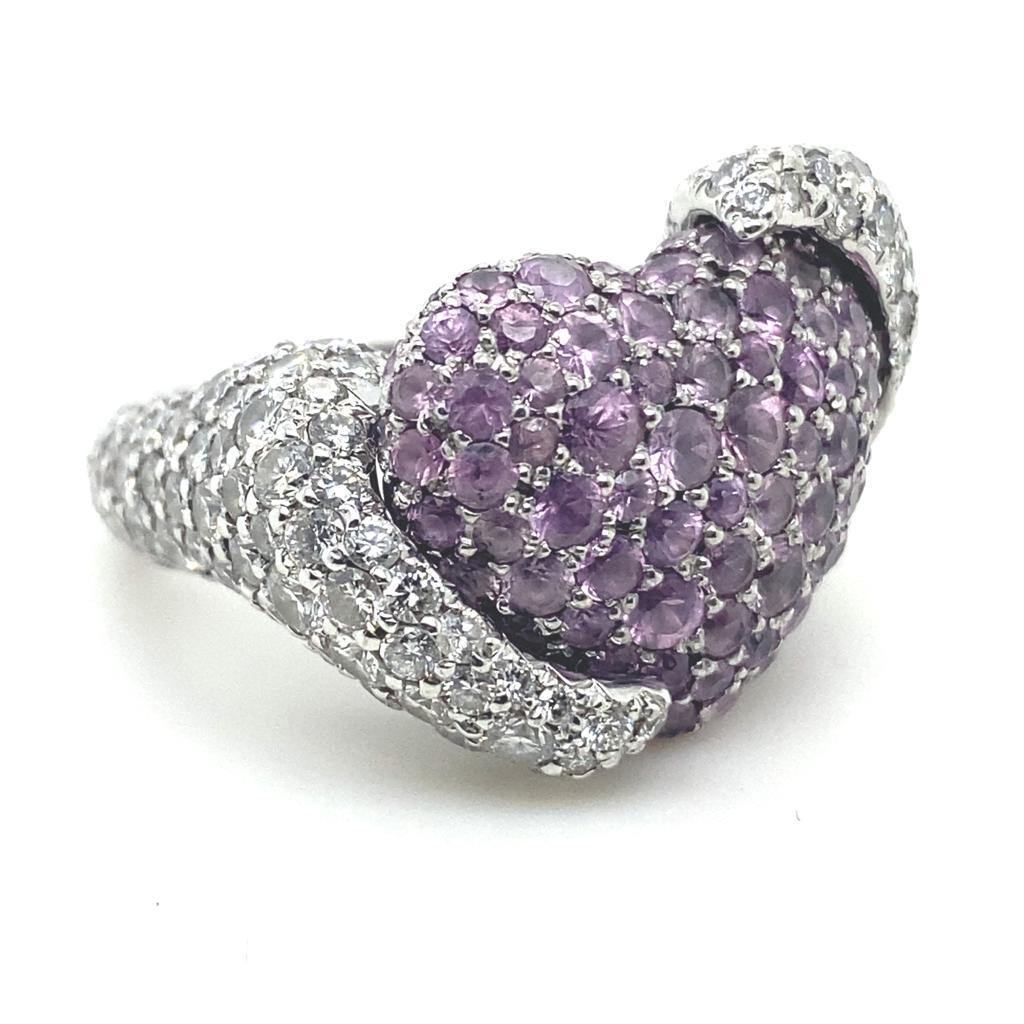 A Chopard By De Grisogono pavé set diamond and pink sapphire 18 karat white gold ring, circa 2000 

This bold and chunky heart shaped ring is a collaboration of The House of De Grisogono and The House of Chopard, the two design aesthetics blending