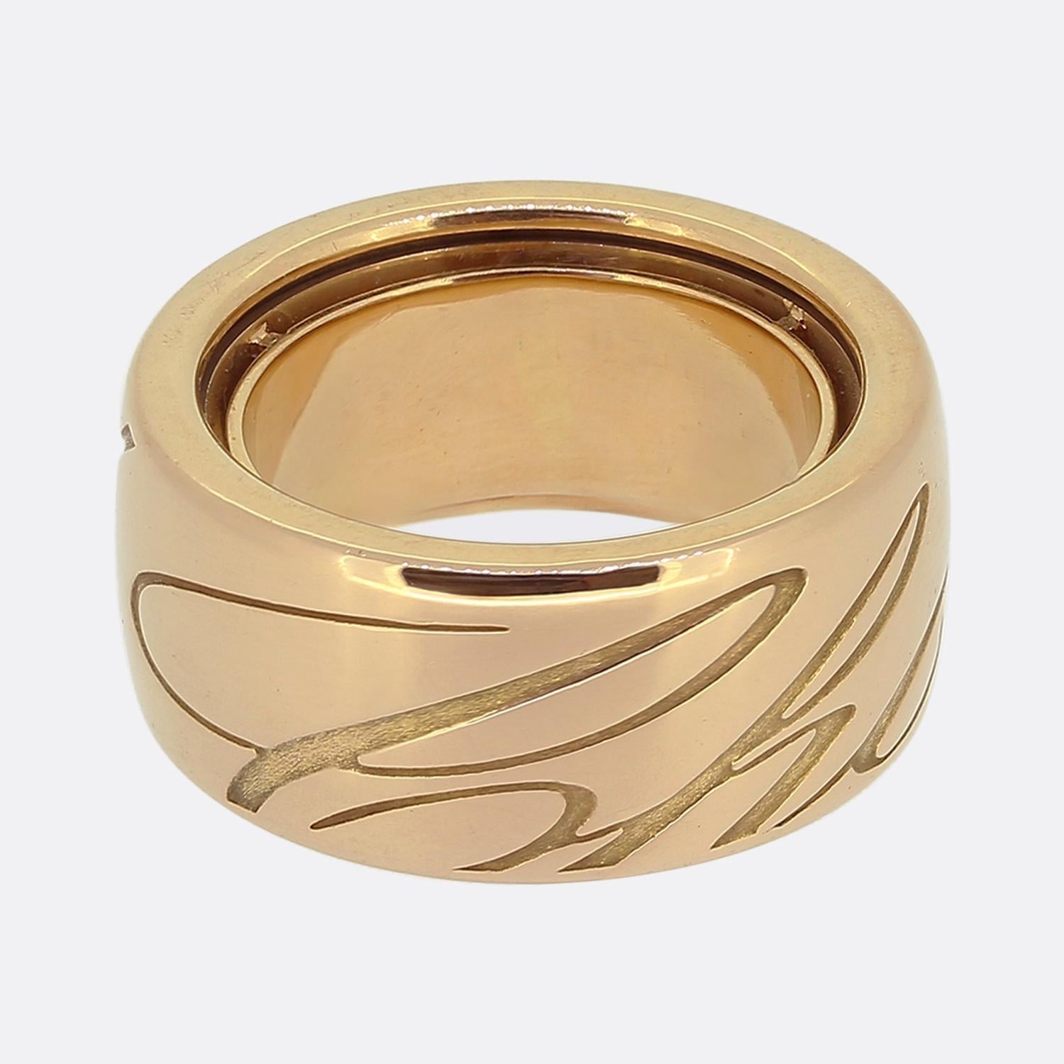 Here we have a wide band ring from renowned French jewellery designer, Chopard. The band is crafted from luxurious 18ct rose gold, featuring a smooth surface with the brand's name elegantly engraved in a flowing script. The ring's bold design makes