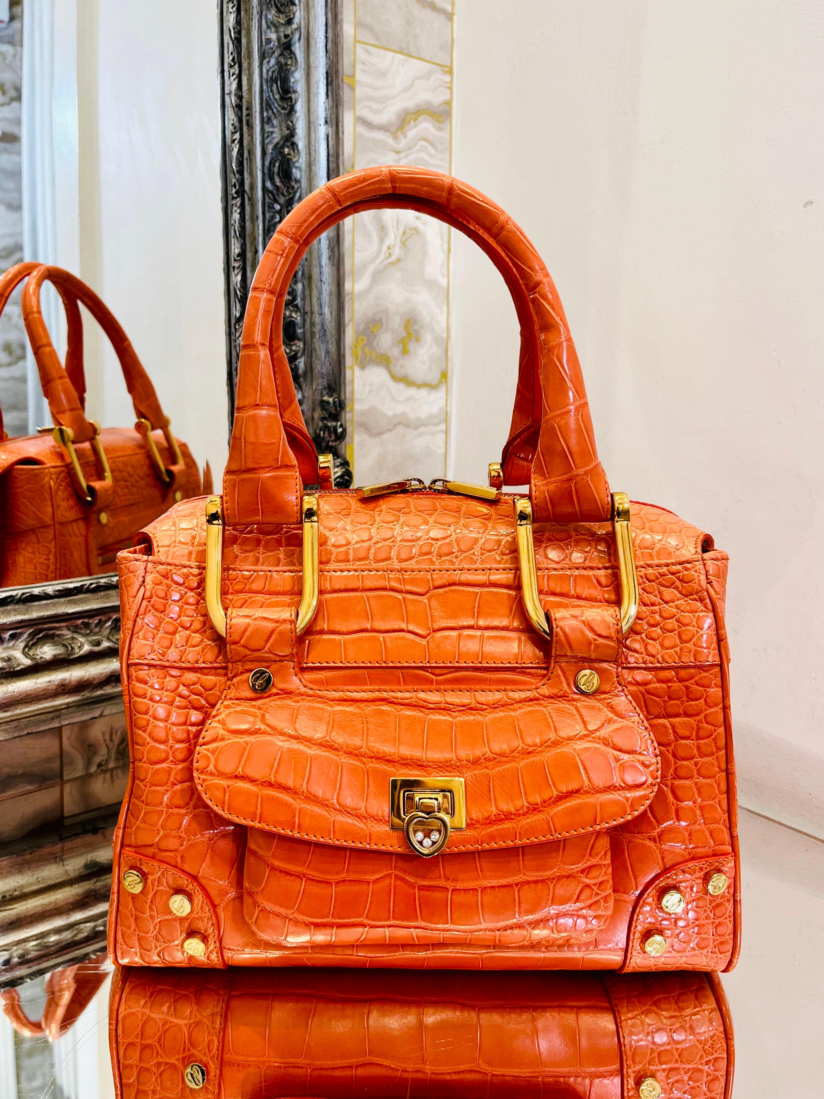 Rare Item - Chopard Crocodile Skin Carolina Bag

Ltd edition - Orange exotic skin bag with top carry/should handles and gold hardware.

Love heart closure with floating crystals to the front feature pocket.

Zipper closure to the bags  main