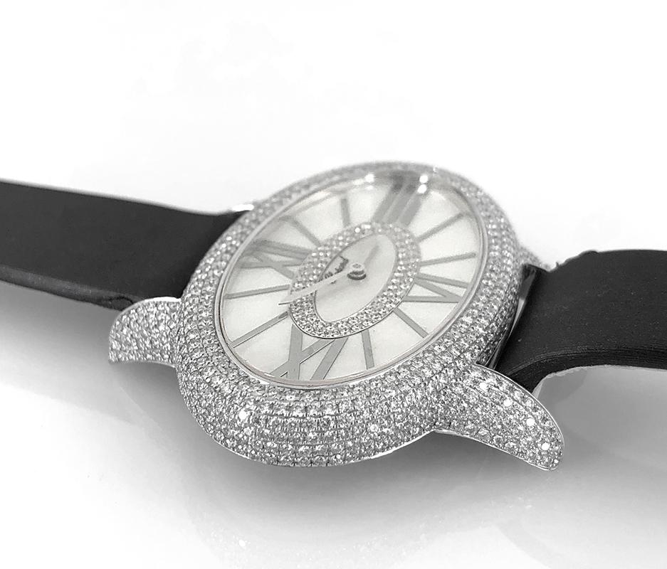 18k White Gold diamond and mother of pearl watch, signed Chopard.

Brand: Chopard
Movement: Quartz
Dial: Mother of Pearl and diamond (76 dia. = 0.28 cts.)
564 diamonds: 2.73 cts.
16 diamonds: 0.34 ct (buckle)
This comes with certificate of