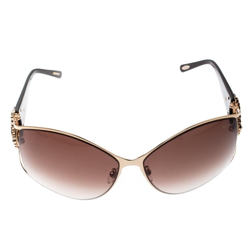 Chopard’s rectangular sunglasses are an example of the brand's luxurious femininity. These slightly oversized glasses feature logos and multicoloured crystals encrusted on the hinges. They are finished with black temples and gradient brown