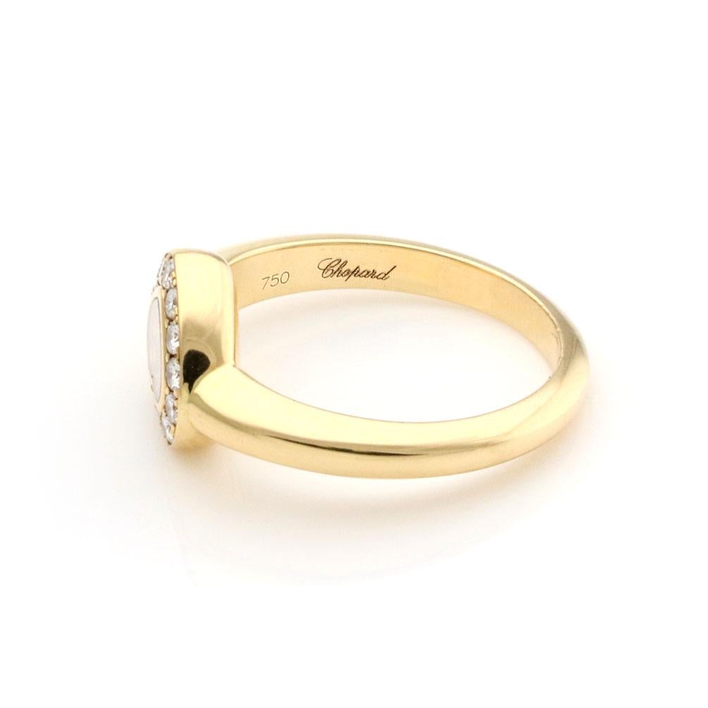 This elegant authentic ring is by Chopard from the Happy Diamond collection. It is crafted from 18k yellow gold with a polished finish. The front center of the ring has a heart frame with glass case and a single 3 points floating diamond. Around the
